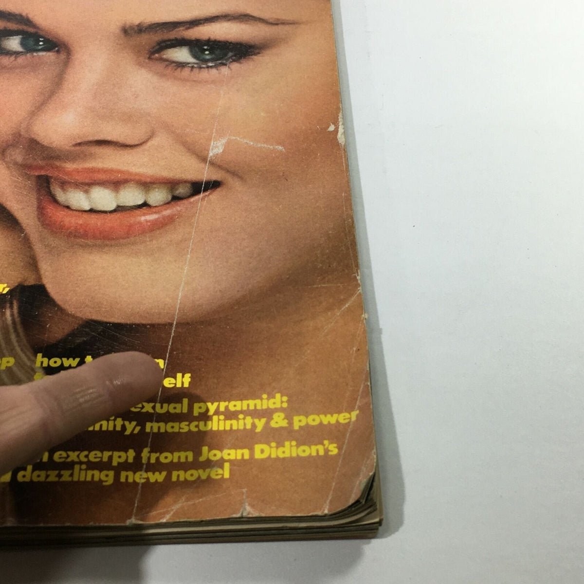Close-up view of the cover of VTG Mademoiselle Magazine February 1977 highlighting the article titles, including relationship and beauty tips, with visible wear that adds character.