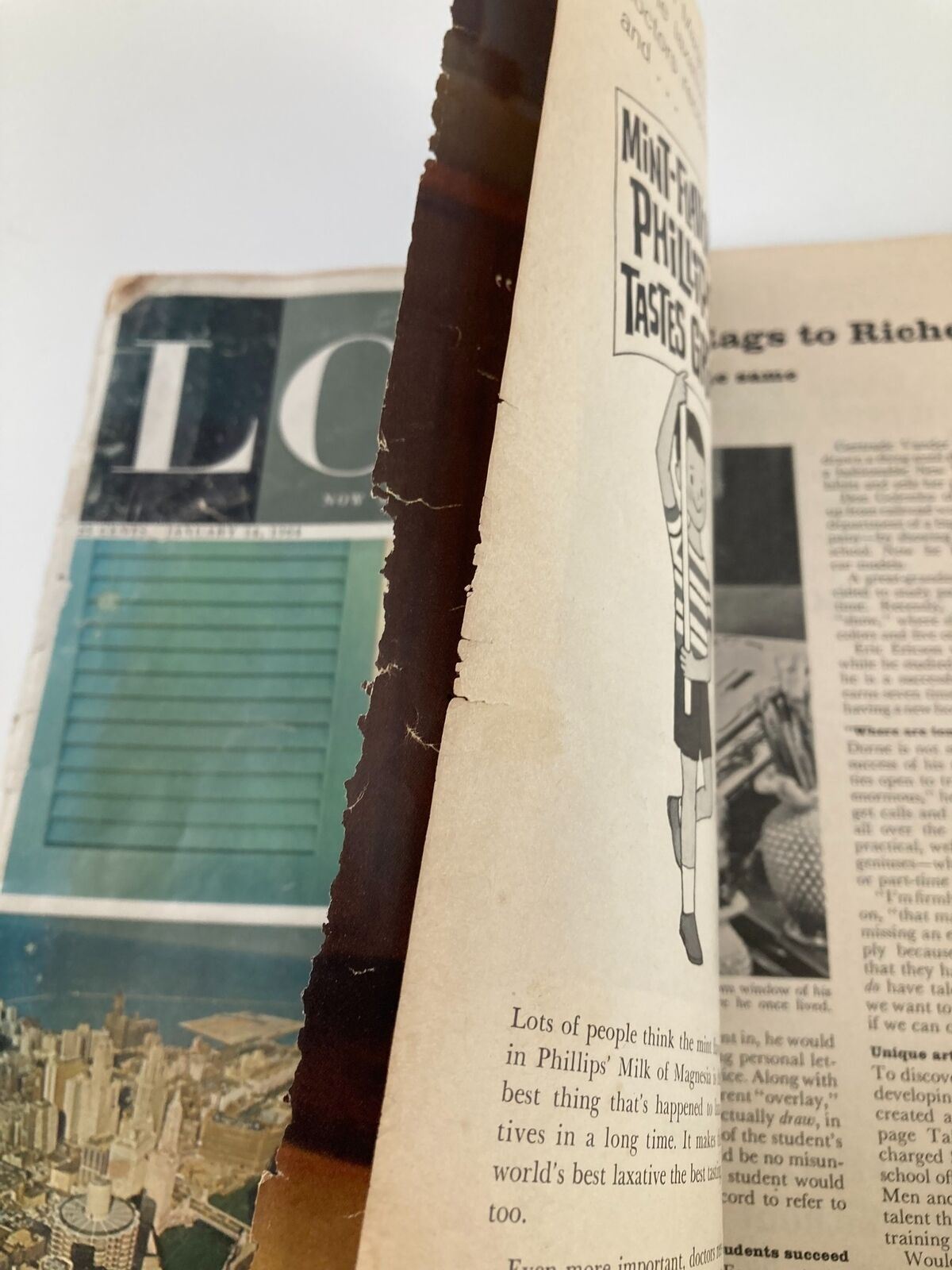 Close-up view of the VTG Look Magazine dated January 14, 1964, highlighting worn edges and spine, showcasing signs of vintage wear.