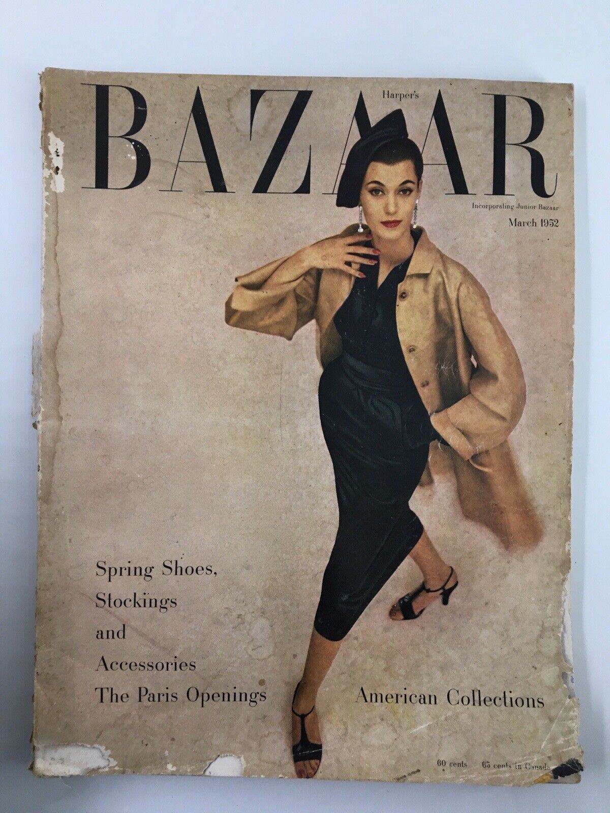 Cover of Harper's Bazaar March 1952, featuring a stylish model dressed in a black outfit and beige coat, promoting Spring Shoes, Stockings, and Accessories from the Paris Openings and American Collections.