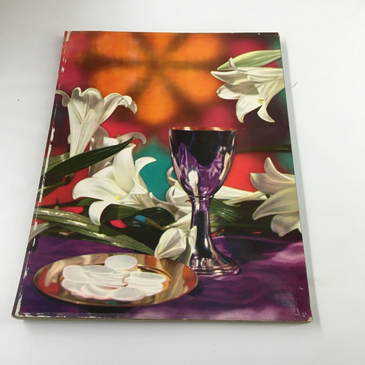 The cover of Ideals Vol. 17 No. 1 March 1960 Easter Issue, showcasing a vibrant composition of lilies, a chalice, and communion wafers on a colorful background, representing the Easter celebration.