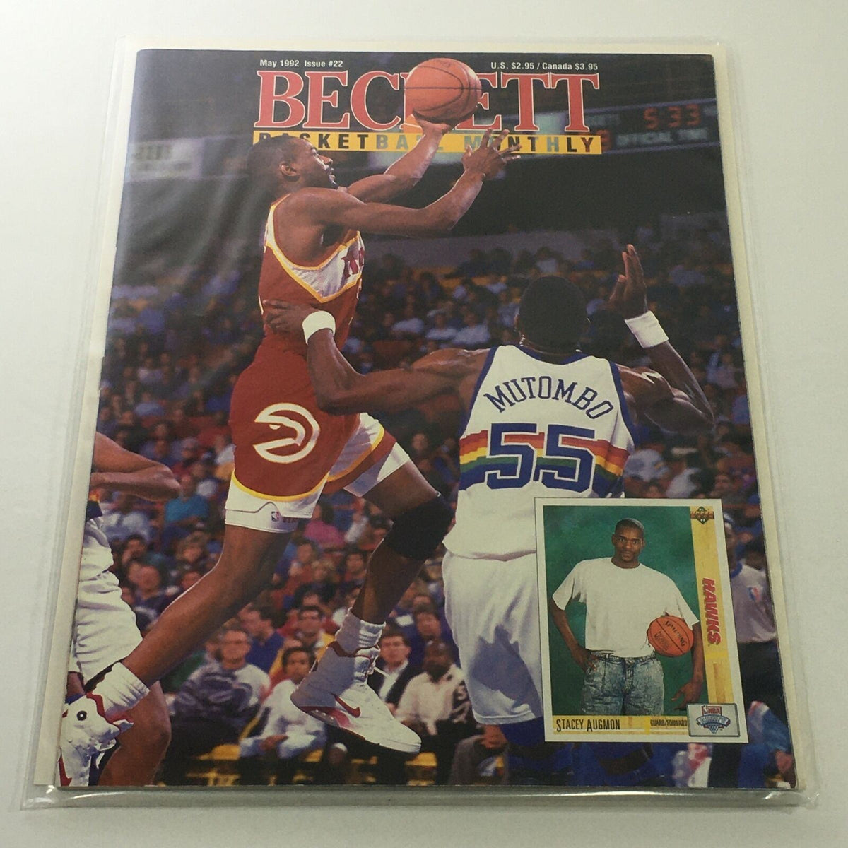 Beckett Basketball Monthly: May 1992 Issue #22 featuring Hawks player Stacey Augmon in action, showcasing a basketball game moment with a prominent image of Dikembe Mutombo in the background.
