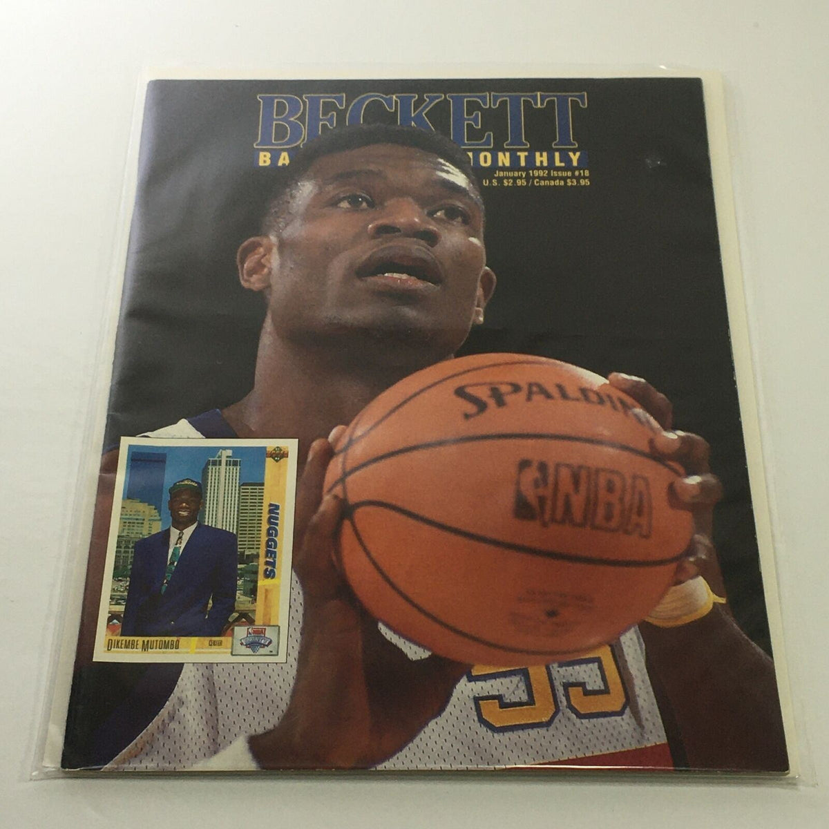 Beckett Basketball Monthly: January 1992 Issue #18 cover featuring Nuggets player Dikembe Mutombo, holding a basketball, with a trading card illustration beside him.