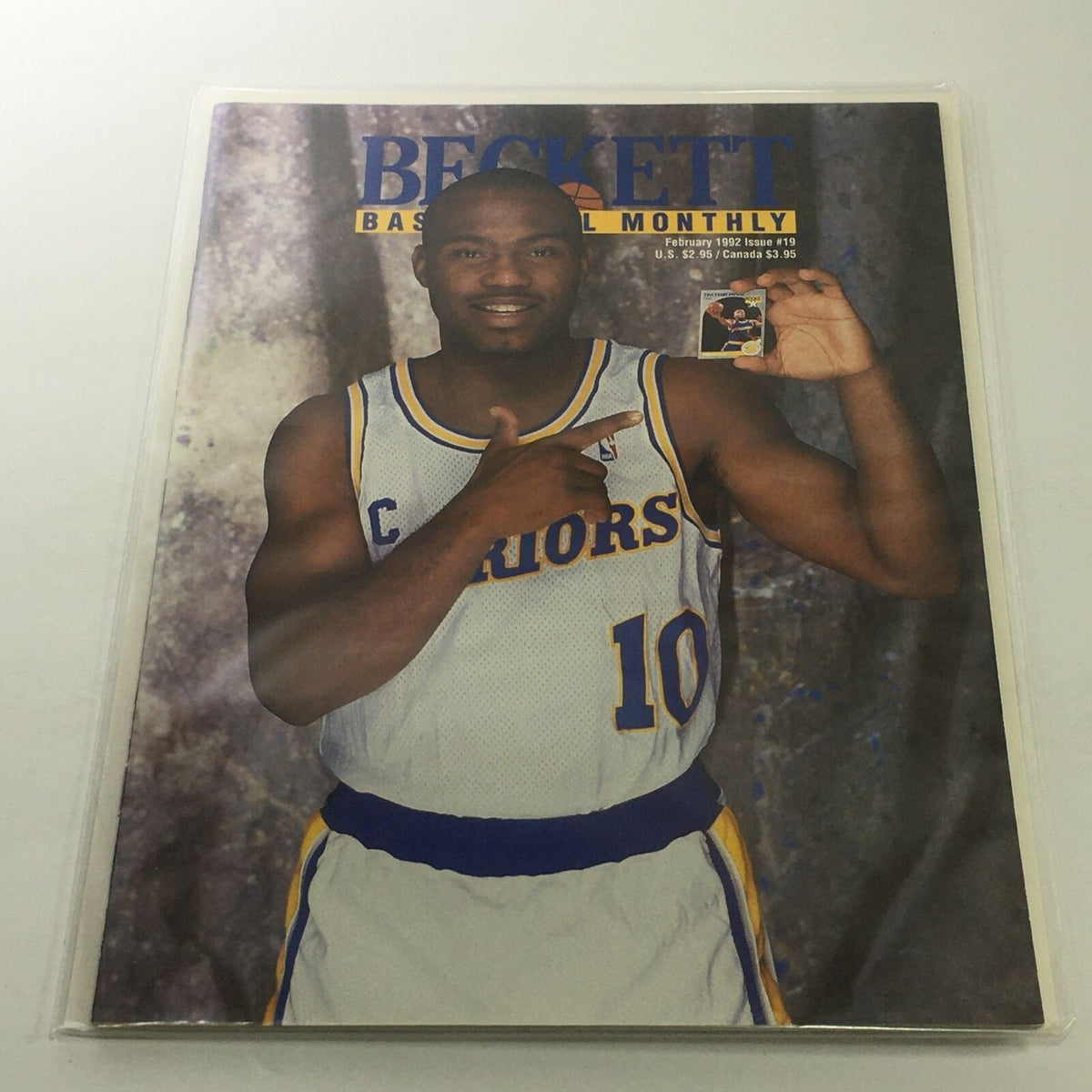 Beckett Basketball Monthly February 1992 Issue #19 featuring Tim Hardaway of the Warriors, showcasing him in a basketball jersey, holding a card while posing against a textured background.