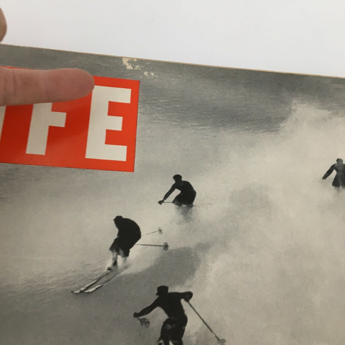 Detailed close-up of the VTG Life Magazine January 24 1938 cover, focusing on the iconic 'LIFE' logo and skiers amidst powdered snow, revealing slight imperfections.