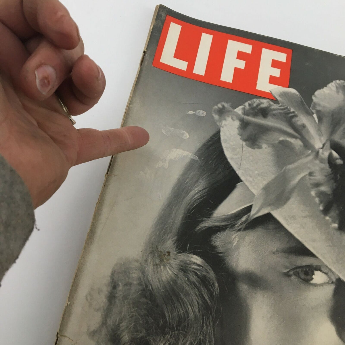 Close-up of the cover of the VTG Life Magazine February 12 1940 featuring a woman's face adorned with an Orchid Valentine hat and the iconic Life logo, showcasing vintage charm.
