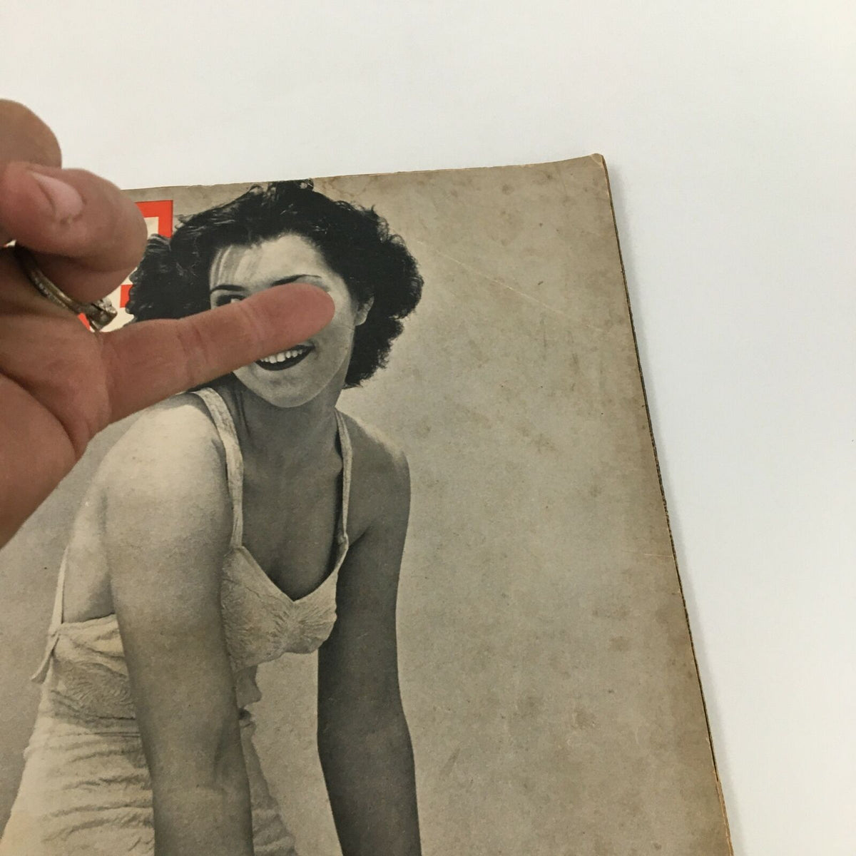 Close-up view of Vintage Life Magazine featuring Diana Barrymore, highlighting the cover image and condition with a finger pointing at her smiling face.