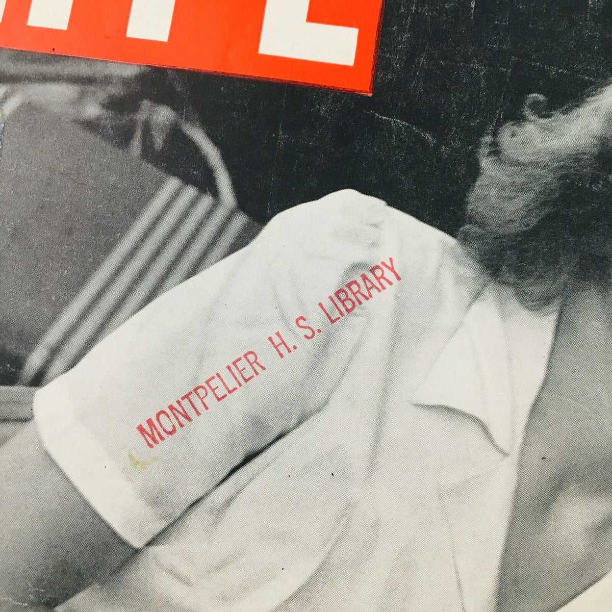 Detailed shot of the sleeve of 'VTG Life Magazine June 23 1941', displaying the stamp of 'Montpelier H. S. Library' on the white shirt of the woman on the cover.
