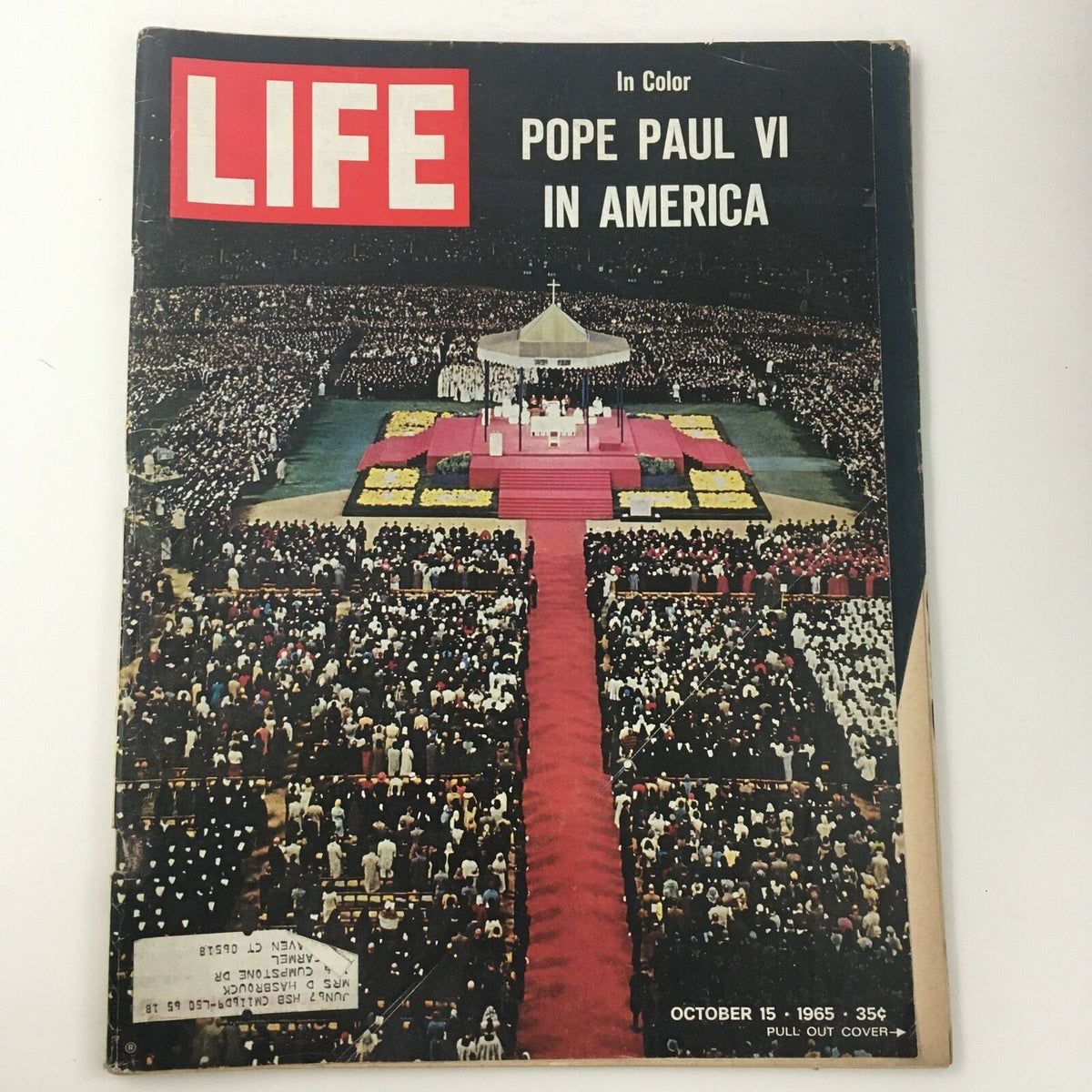 Cover of Life Magazine from October 15, 1965 featuring Pope Paul VI in America, showcasing a large crowd gathered in a stadium setting, with a stage and red carpet.