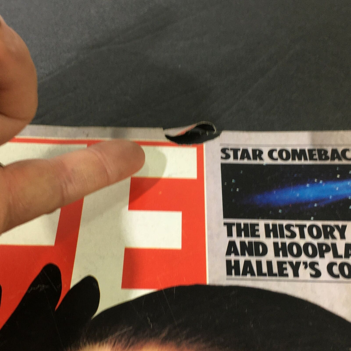 Close-up view of cover damage on VTG Life Magazine October 1985, displaying the magazine title and article details including Joan Collins and Halley's Comet.