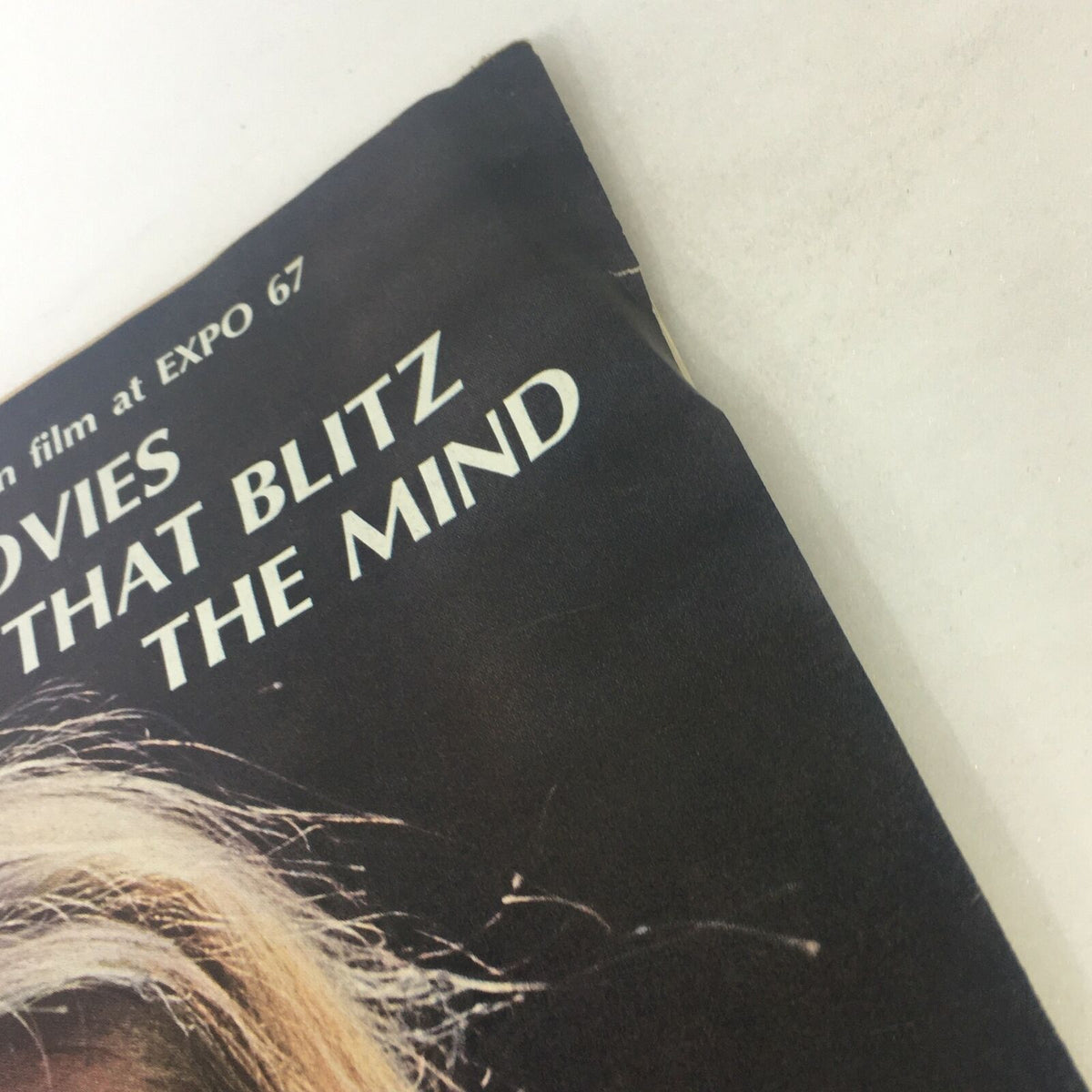 Close-up view of the corner of the VTG Life Magazine from July 14, 1967, highlighting the text 'Movies That Blitz the Mind' along with a slight wear at the edge, representing its vintage quality.