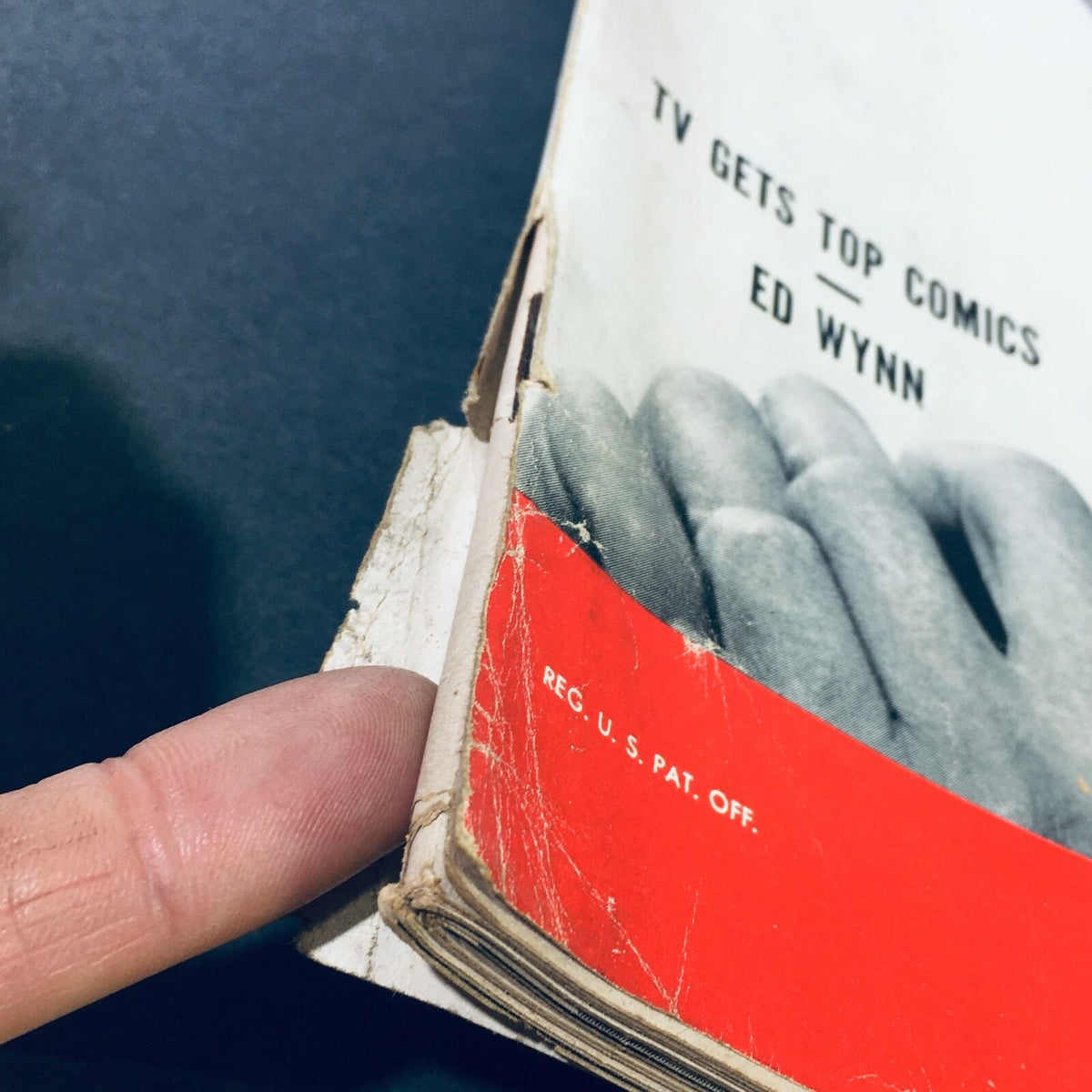 Detailed image of the spine and edge of 'VTG Life Magazine October 23 1950 - Ed Wynn TV Gets Top Comics / Russian Trouble.' The photo captures a hand indicating wear, tears, and a label on the magazine, reflecting its cherished vintage status.