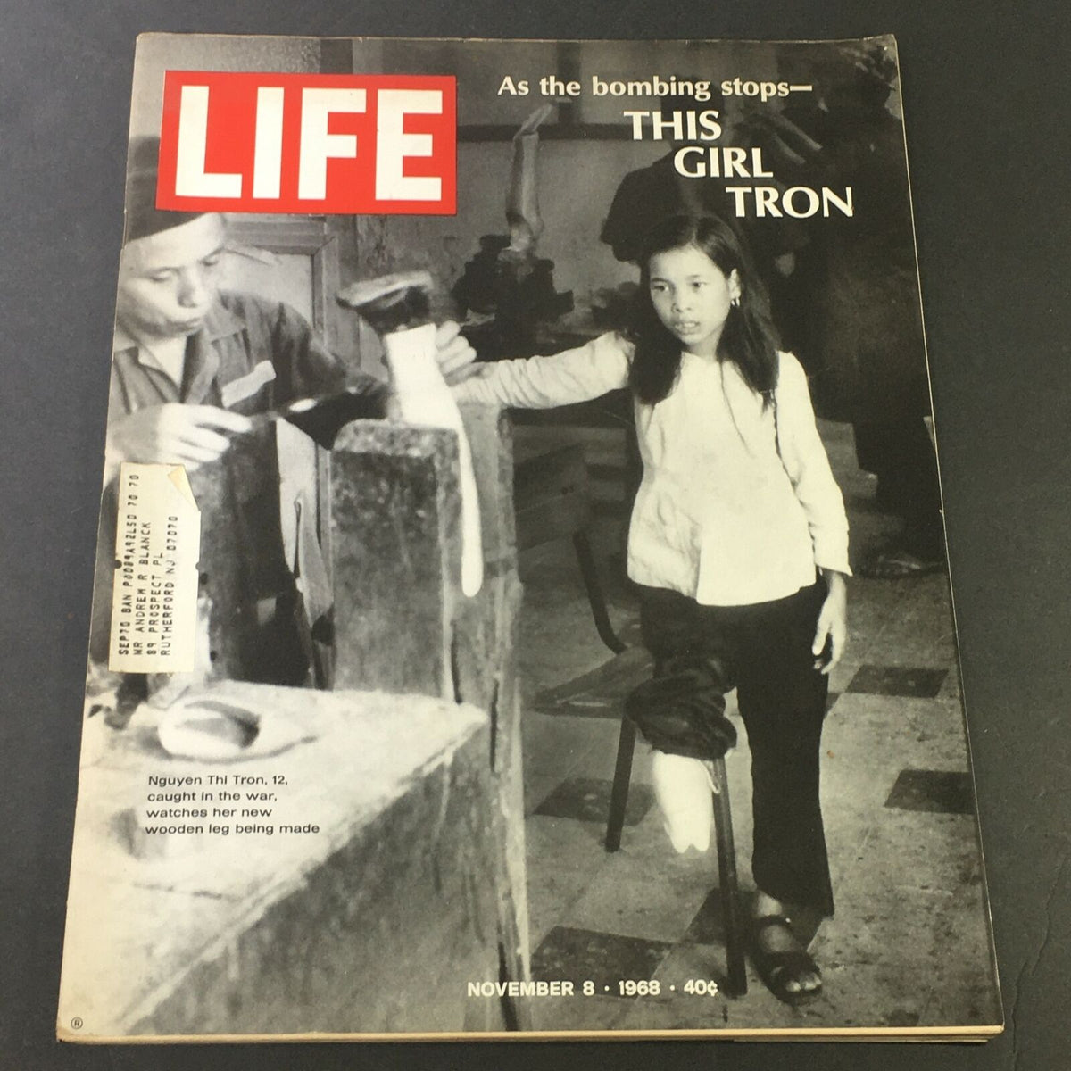 Cover of VTG Life Magazine, November 8, 1968, featuring Nguyen Thi Tron, a young girl observing the making of her wooden leg, highlighting the impact of war on children.