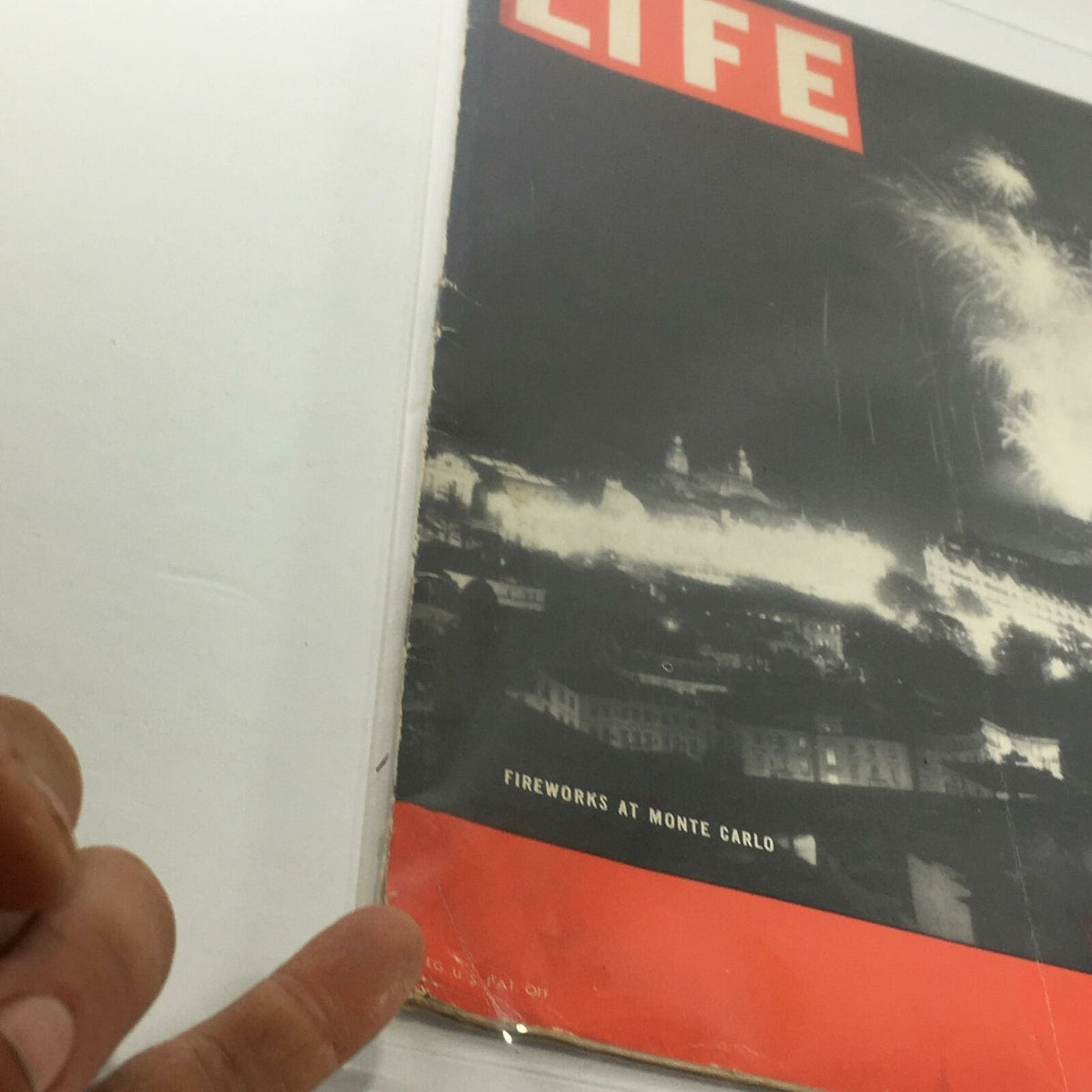 Close-up view of the Vintage Life Magazine cover from February 28, 1938, displaying 'Fireworks At Monte Carlo' along with visible wear, showcasing its historical value.