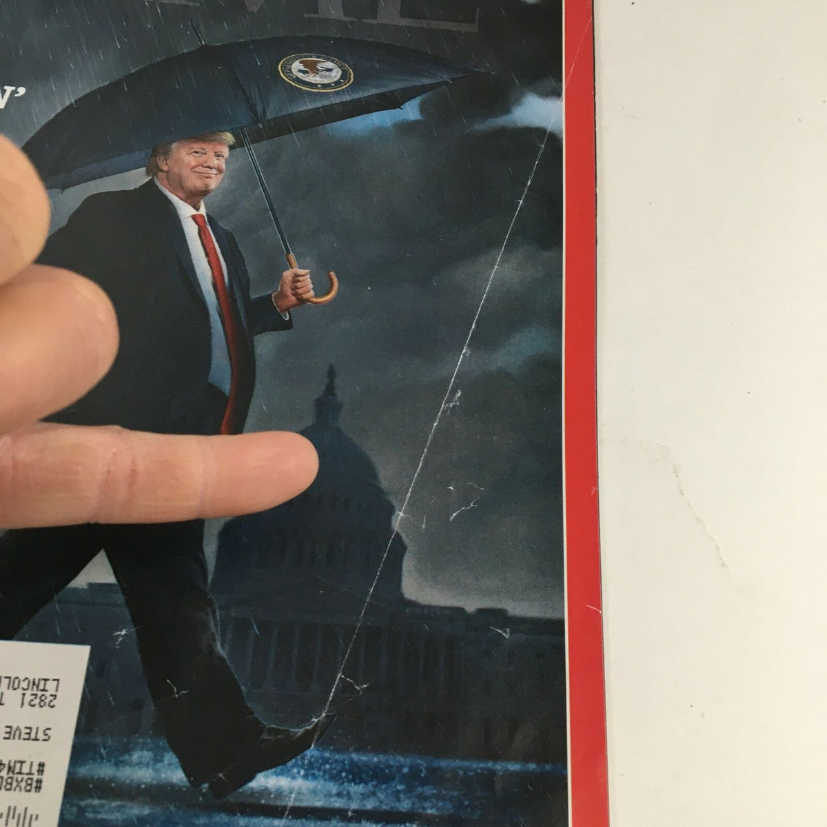 Close-up of the Time Magazine cover from April 9 2019 showing Donald Trump with an umbrella, highlighting details of the magazine featuring 'Just Singin' The Trump Reboot'.