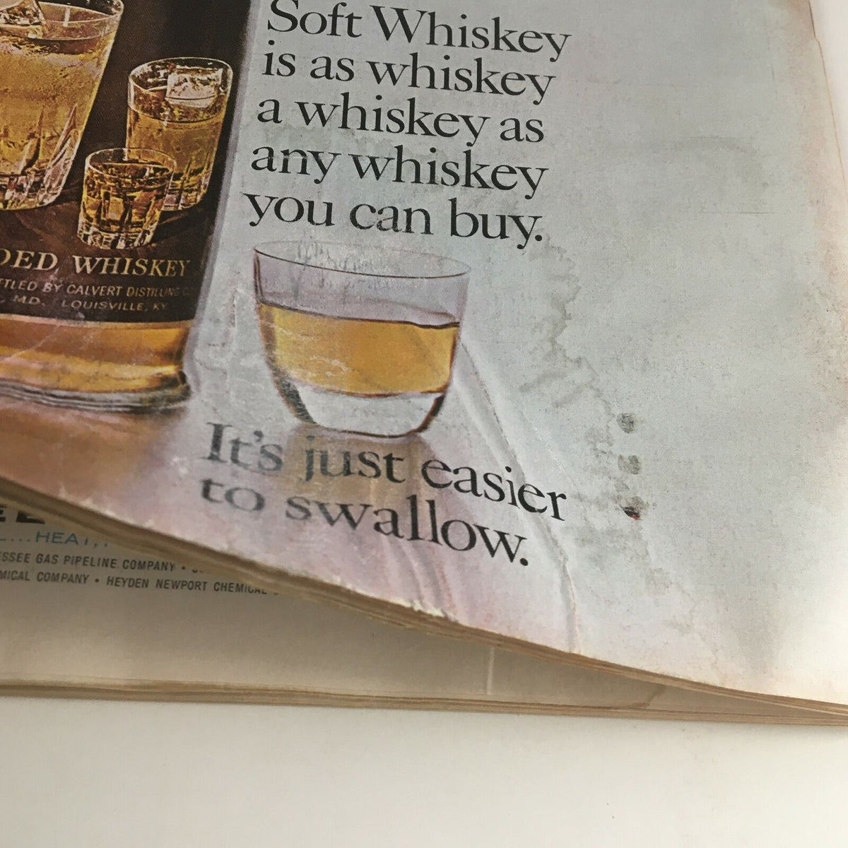 Close-up of a vintage advertisement in Time Magazine May 15, 1964, showcasing Soft Whiskey with the tagline 'It's just easier to swallow,' featuring glasses of whiskey.