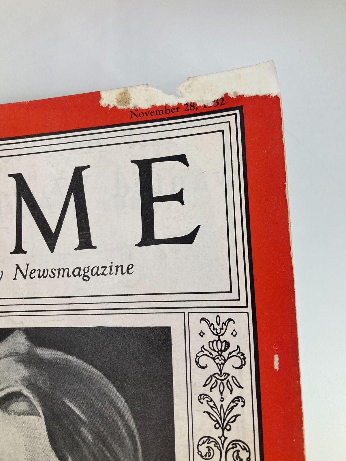 Close-up of the corner of a vintage Time Magazine dated November 28, 1932, showing signs of wear with a tear and the date prominently displayed.