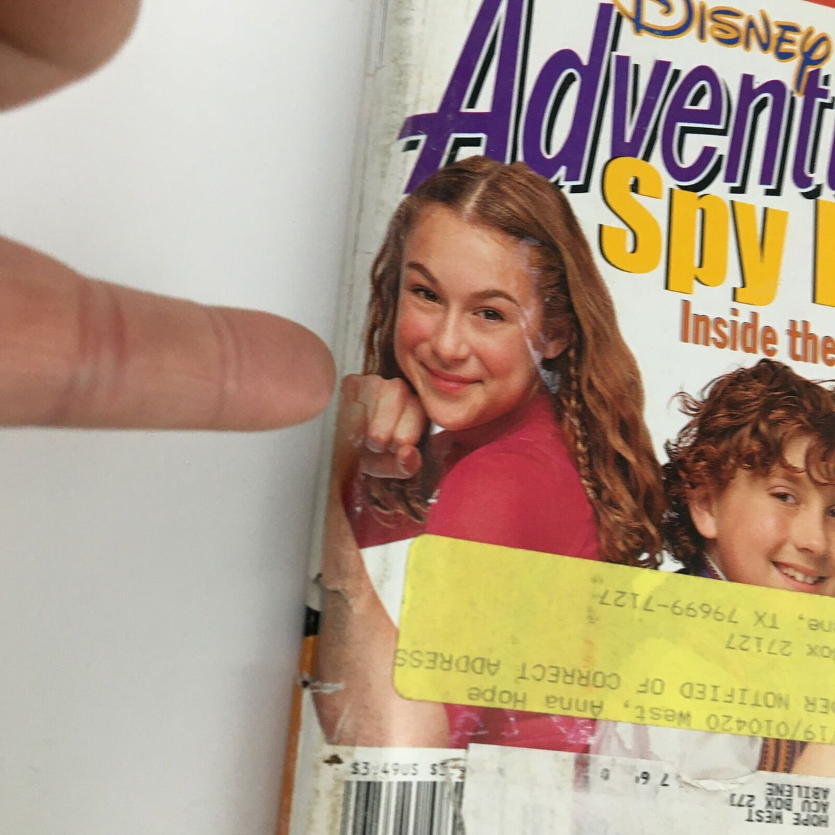 Close-up view of the Disney Adventures Magazine from April 2001 featuring content on Spy Kids, highlighting a smiling girl on the cover with a finger pointing towards it.