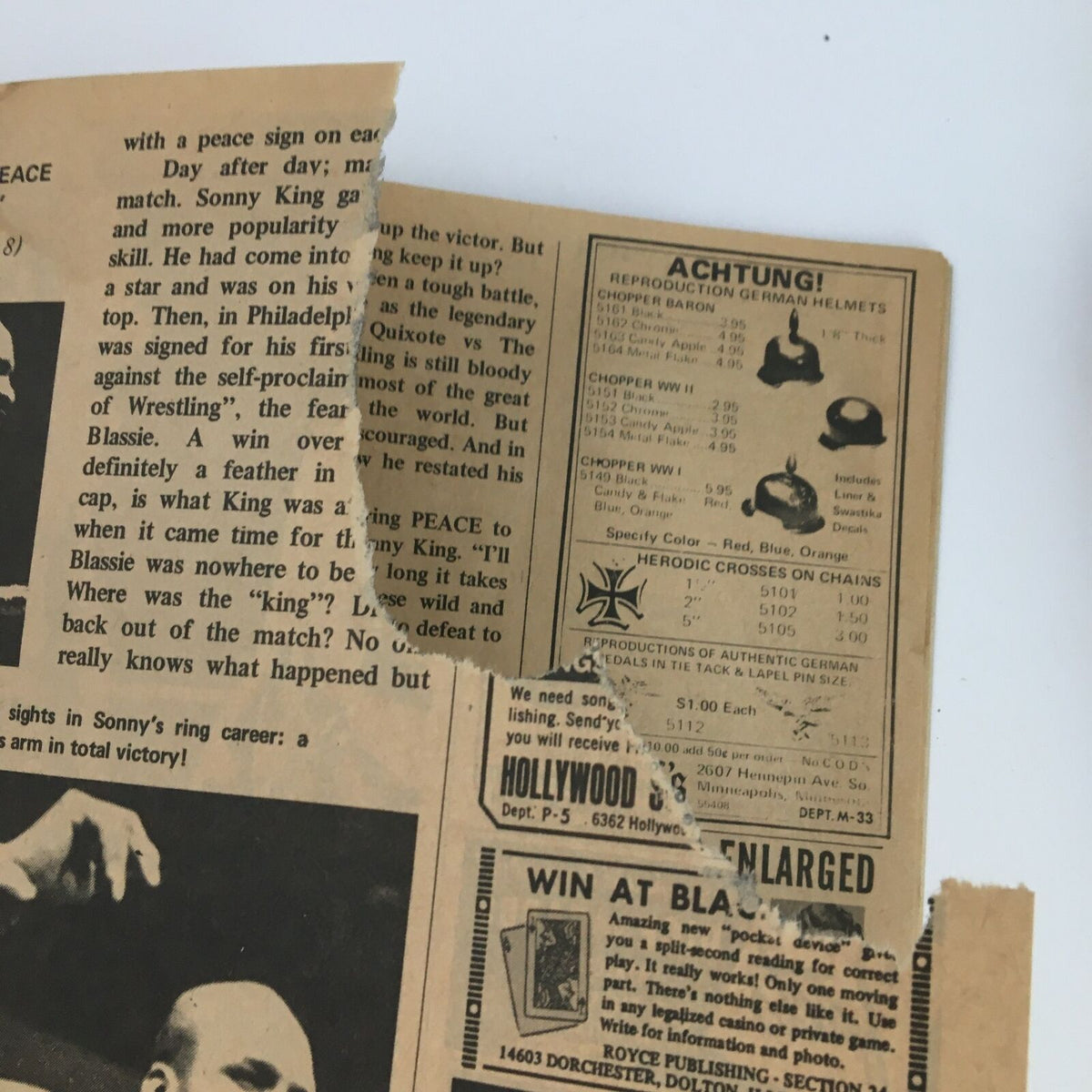 A close-up image from 'The Big Book of Wrestling' May 1973, revealing the torn page of the magazine, featuring advertisements and context around wrestling personalities, representing the magazine's aged condition and authenticity.