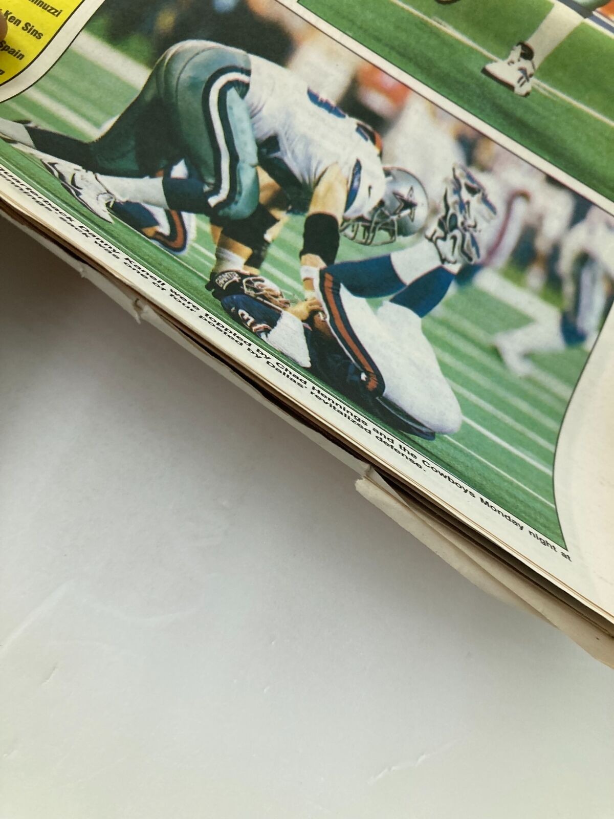 Football player tackling an opponent during a Dallas Cowboys game featured in the Dallas Cowboys Weekly Newspaper September 26 1998 Vol 24 #15 Troy Aikman.