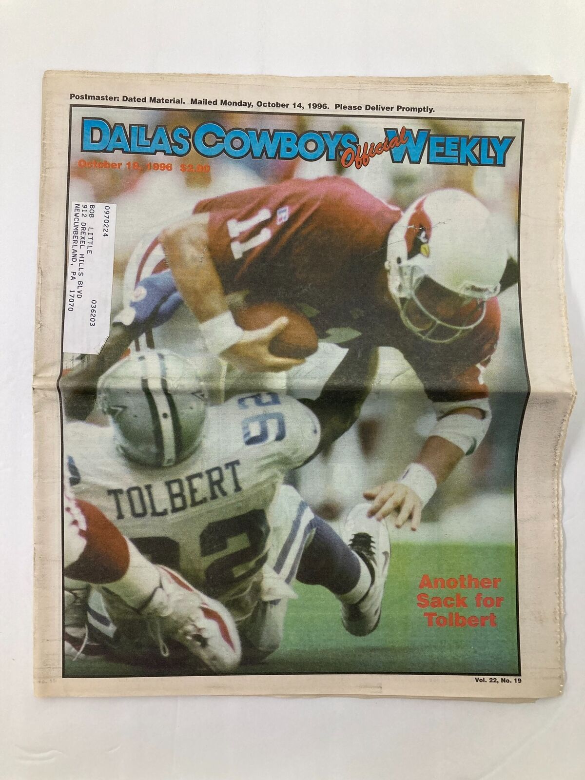 Dallas Cowboys Weekly Newspaper from October 19, 1996, featuring Tony Tolbert making a tackle against a Cardinals player, showcasing the excitement of NFL gameplay. Vol 22 #19.