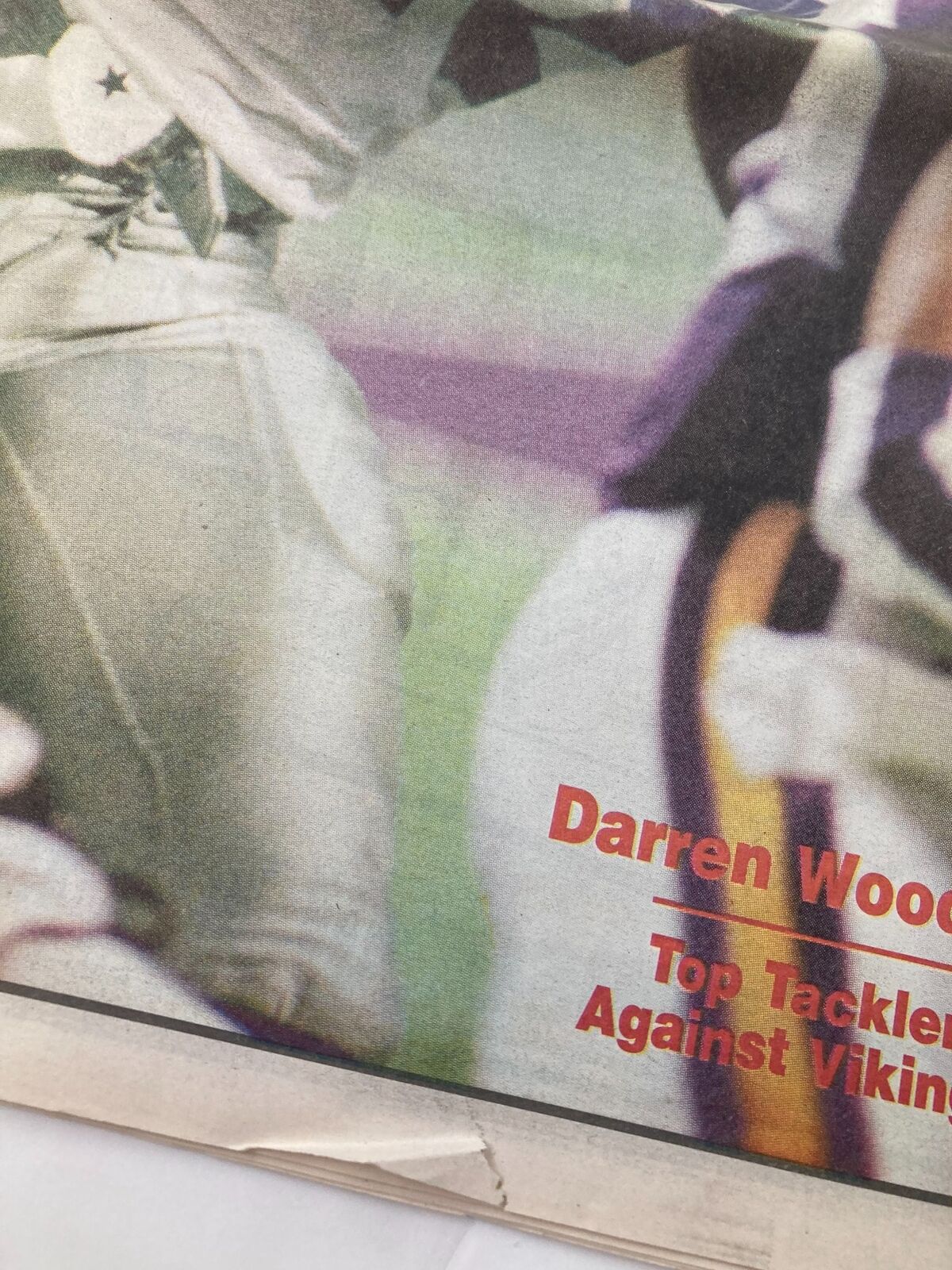 Close-up of the cover of Dallas Cowboys Weekly Newspaper September 23 1995, emphasizing Darren Woodson's achievements as the top tackler. The image captures the intensity of football.
