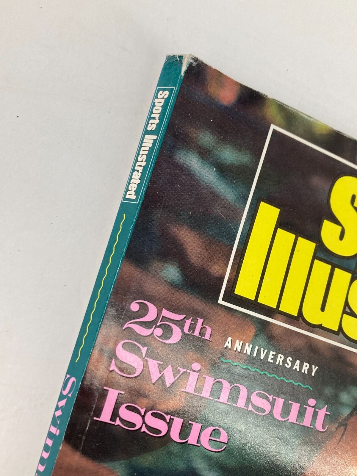 Side view of the spine of the 1989 VTG Sports Illustrated Magazine showcasing its title and 25th Anniversary Swimsuit Issue.