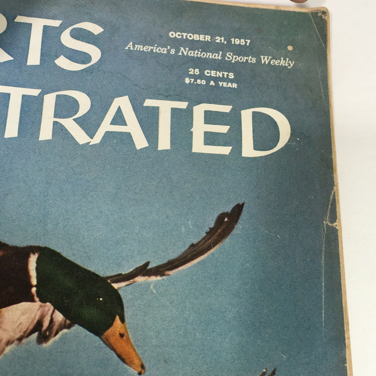 Close-up of the vintage Sports Illustrated Magazine cover from October 21, 1957 titled 'Wings at Dawn', showcasing the title and publication details.