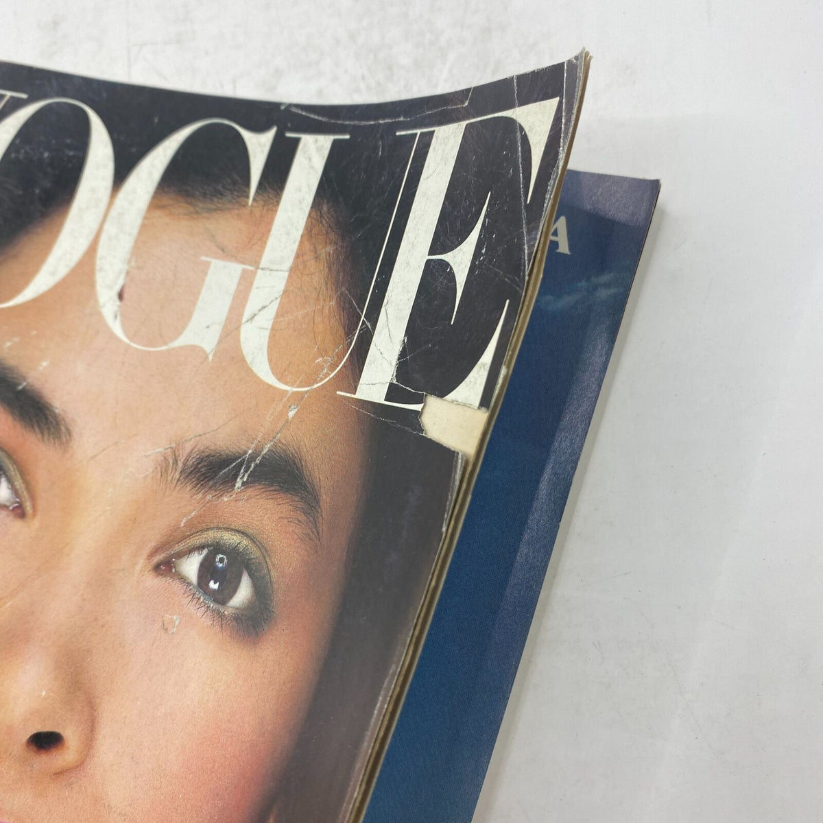 Side view of the VTG Vogue Magazine January 1986 featuring a close-up of model Linda Spierings' face, highlighting the magazine's vintage cover design and condition.