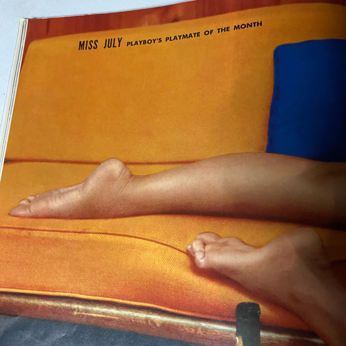 Centerfold page from Playboy Magazine July 1959 showcasing the legs of Playmate Yvette Vickers, lying on an orange couch, highlighting her as Playmate of the Month.