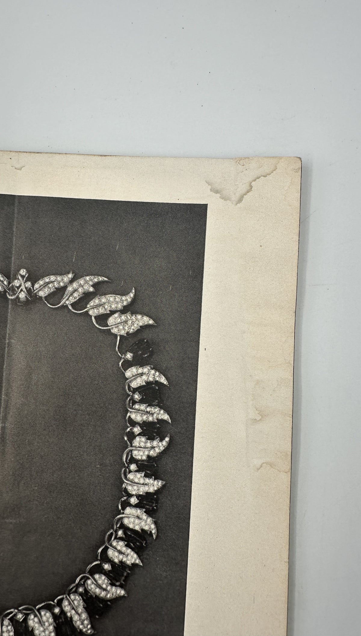 The New Yorker Magazine May 26, 1956 Golf Course Arthur Getz Cover, showing an interior black-and-white jewelry advertisement with a jeweled necklace and visible water staining.