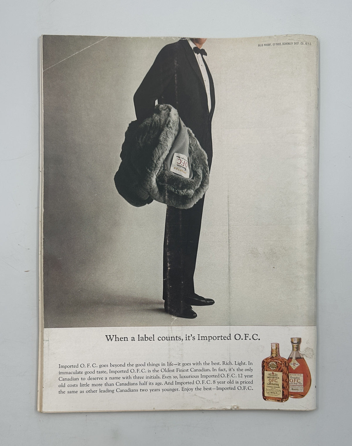 The New Yorker Magazine February 16, 1963 NYC Traffic Alan Dunn Cover interior advertisement showing a tuxedoed man carrying a fur-lined bag beside vintage liquor bottles.