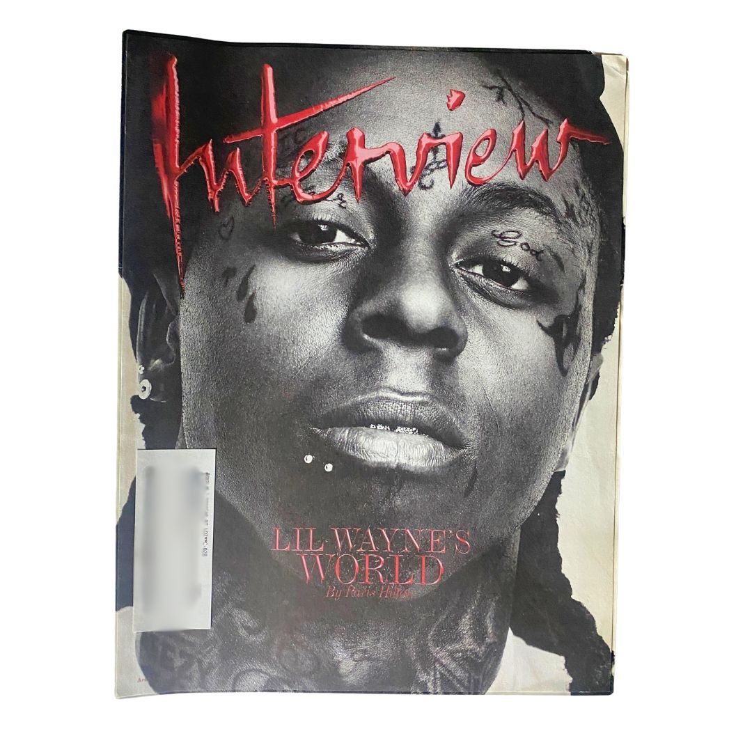 Cover of Interview Magazine April 2011 featuring Lil Wayne's World by Paris Hilton, showcasing a striking portrait of Lil Wayne with prominent tattoos and bold title lettering.