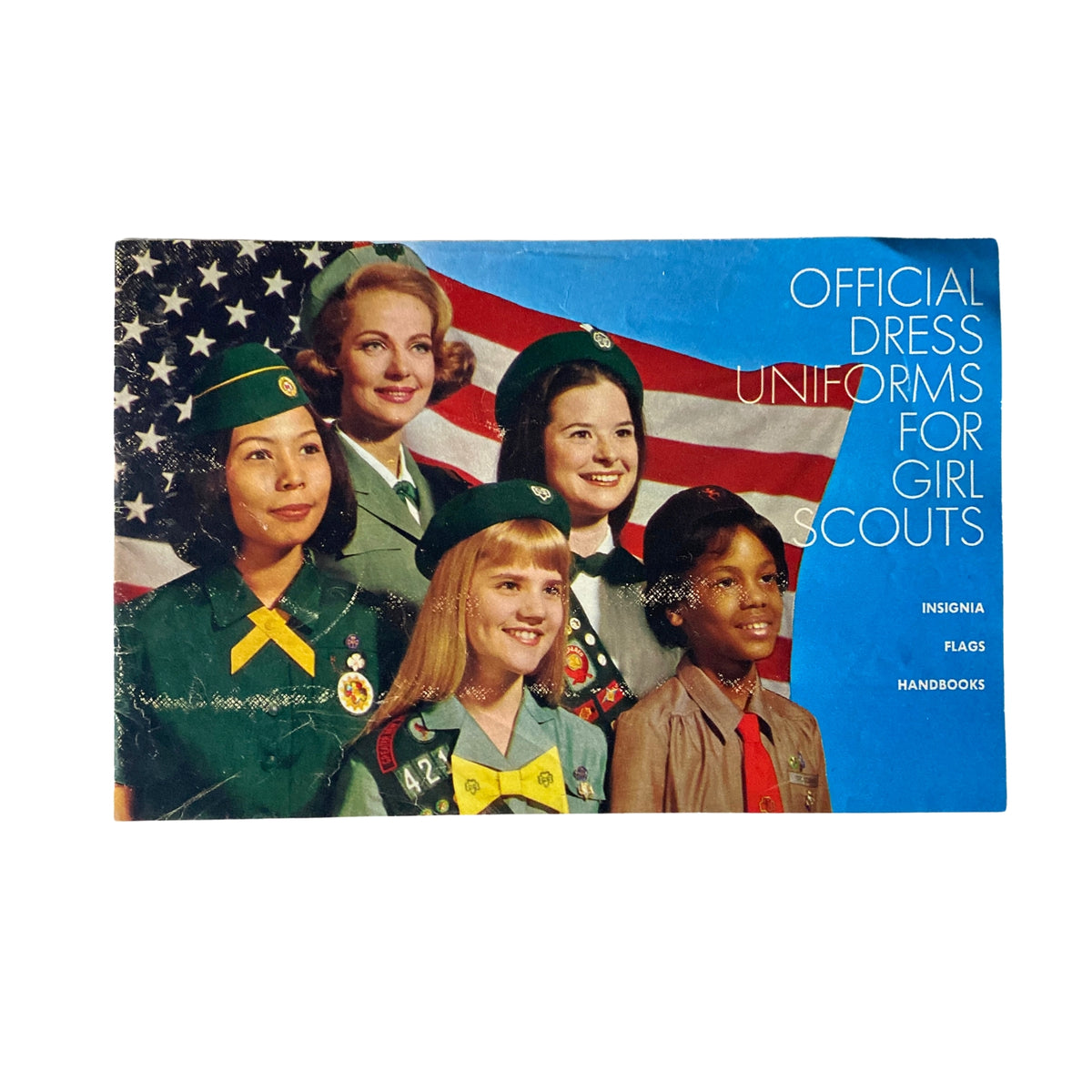 1967 Official Dress Uniforms for Girl Scouts Catalog cover featuring a group of girl scouts in official uniforms with an American flag backdrop.