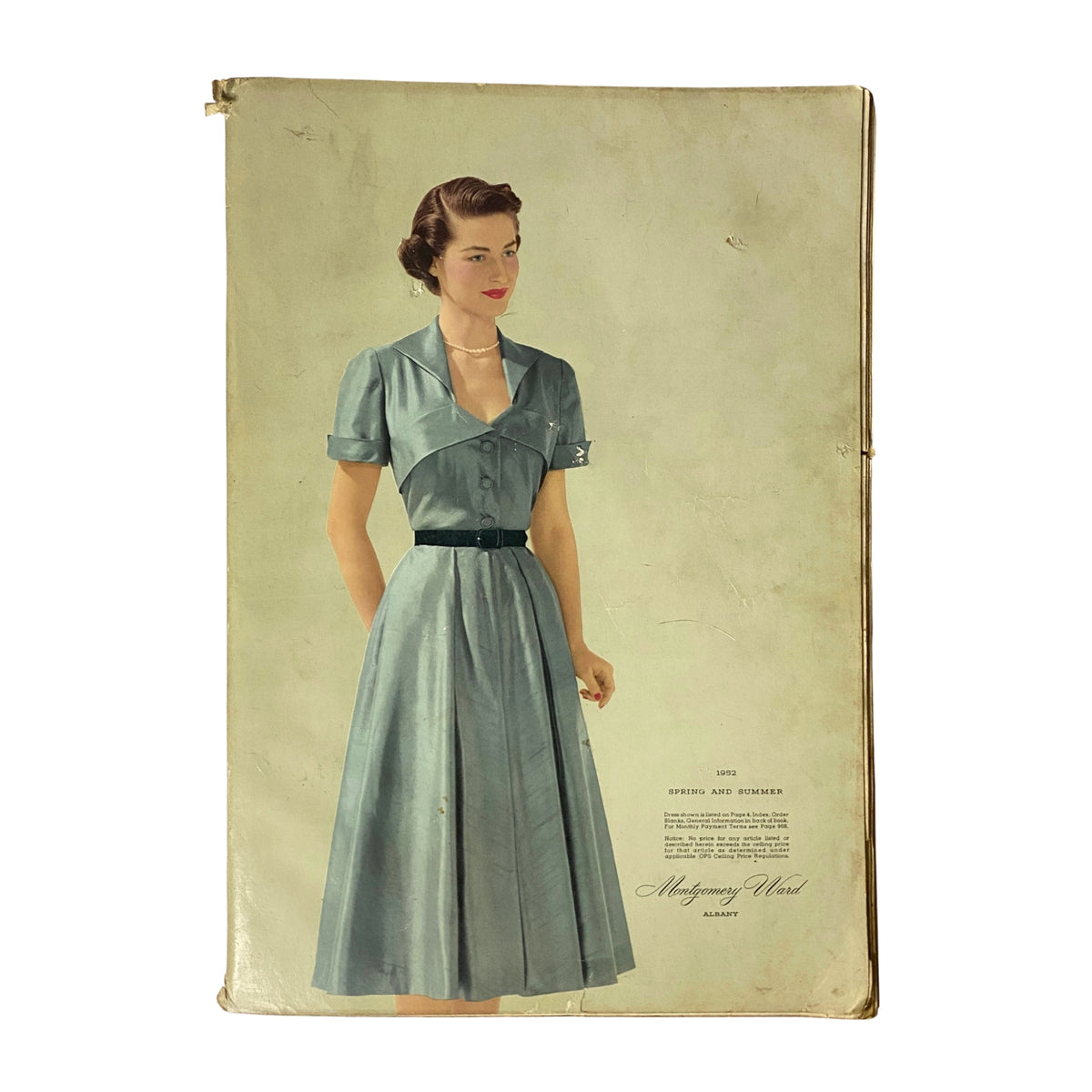 Cover image of the 1952 Montgomery Ward Albany Spring and Summer Catalog featuring a woman in a vintage blue dress, embodying mid-century fashion elegance.