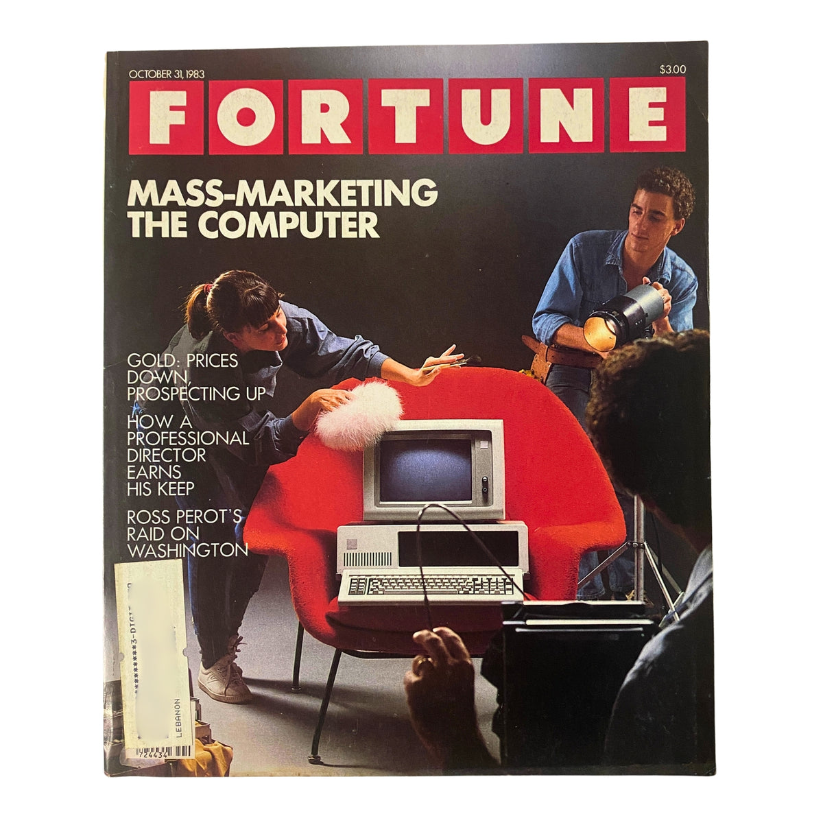 Fortune Magazine cover from October 31, 1983, featuring the headline 'Mass-Marketing The Computer'. The cover shows a woman playfully cleaning a computer in front of a red chair, while a man prepares lighting equipment in the background. This vintage magazine includes articles on economic trends and technology.