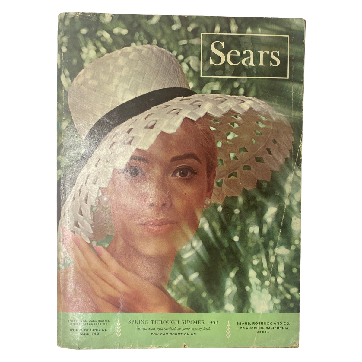Cover image of the 1964 Sears Mr. John Classic Hats Spring - Summer Catalog featuring a model wearing a stylish white sun hat with a black ribbon.