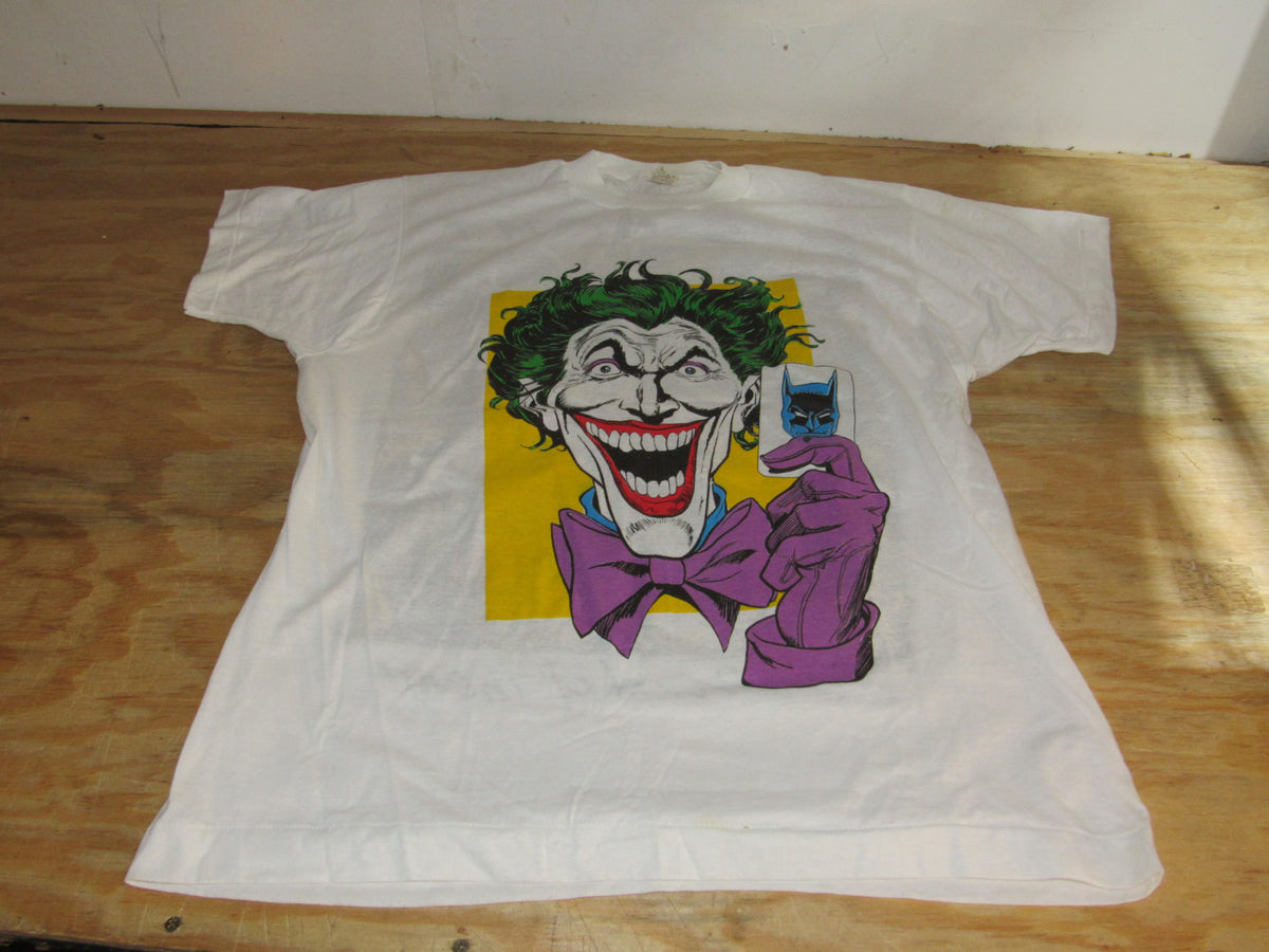 Screen Stars Joker with Batman/U.S Army We're Proud of Them Size L NWOT - Front view of a white t-shirt featuring a colorful graphic of the Joker character from Batman, showcasing his iconic smile and purple bow tie.