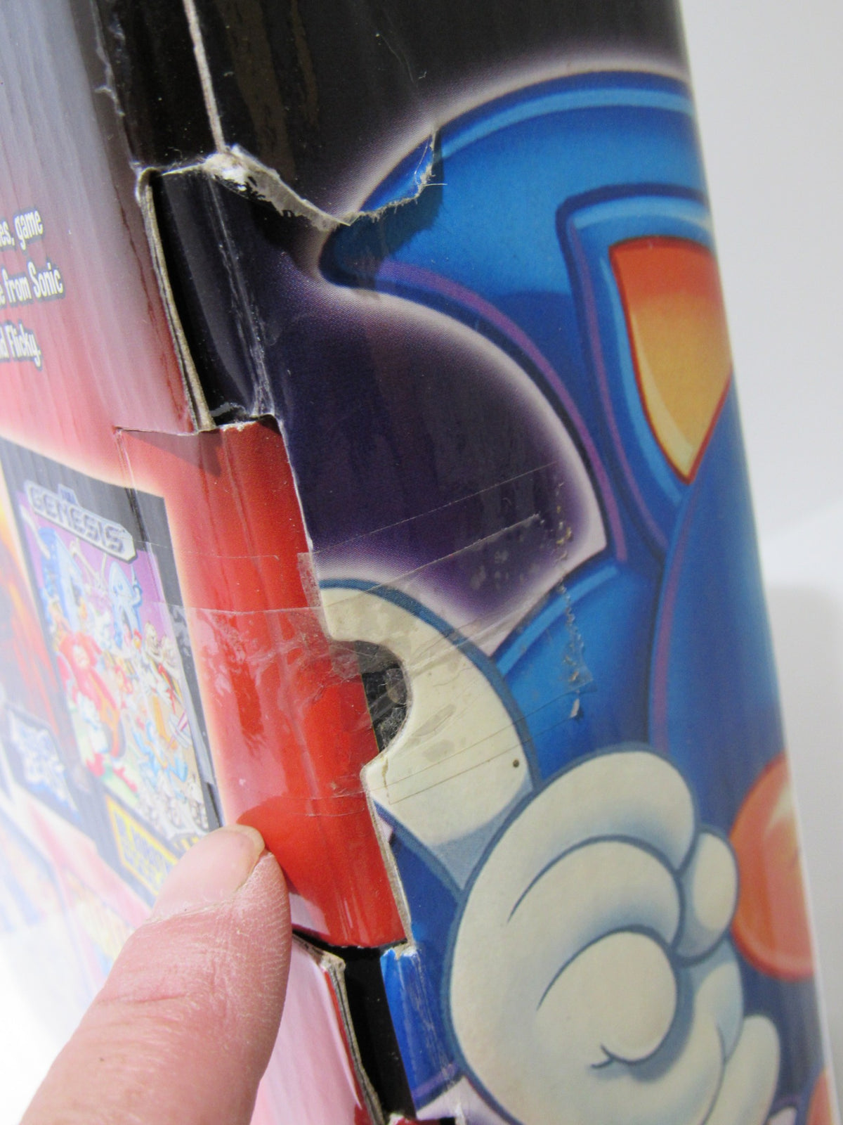 Side view of the Sega Genesis Radica Plug and Play 6 Games-In-One box demonstrating minor damage while featuring Sonic character graphics.