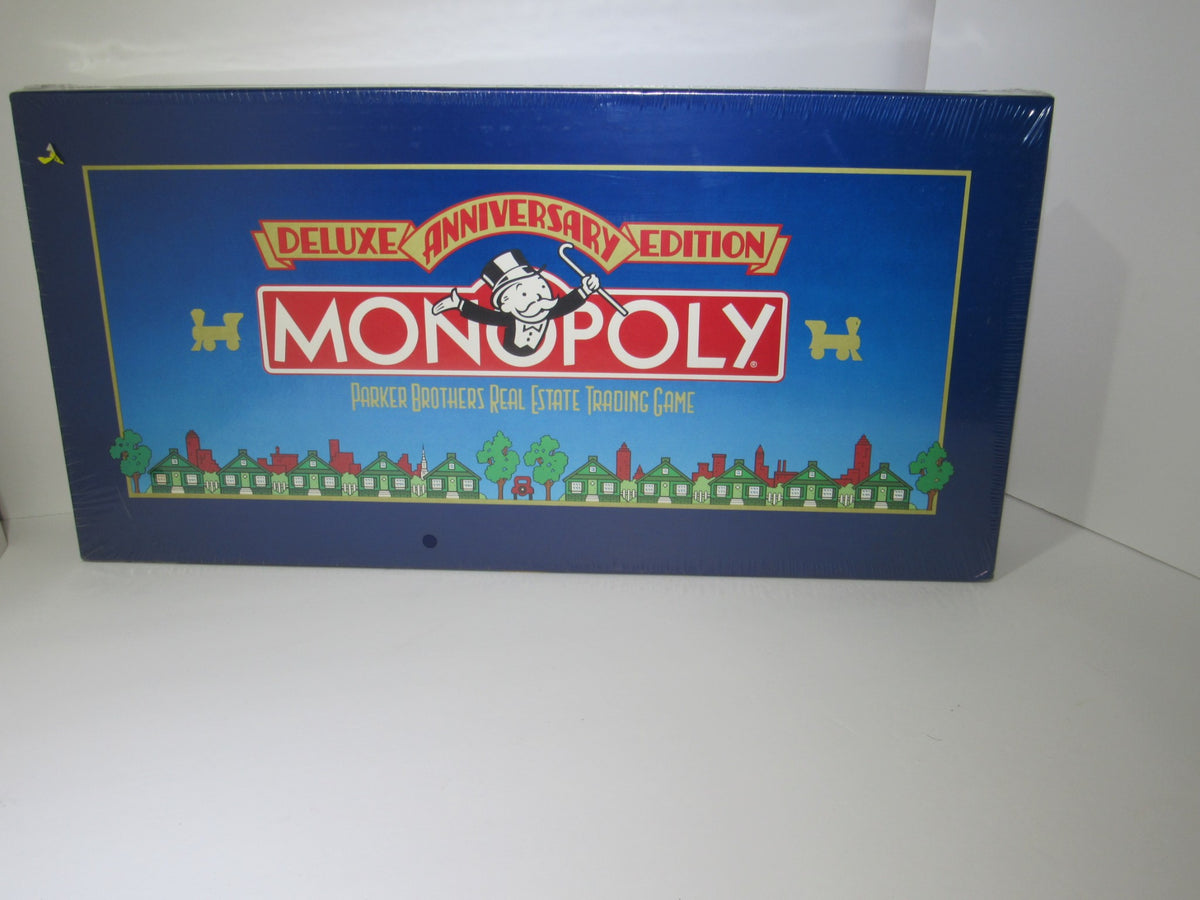 NEW 1985 PARKER BROTHERS MONOPOLY FAMILY GAME DELUXE ANNIVERSARY EDITION - Sealed box featuring colorful artwork with Monopoly branding, showcasing the game title and Parker Brothers logo, highlighting the vintage collectible aspect.