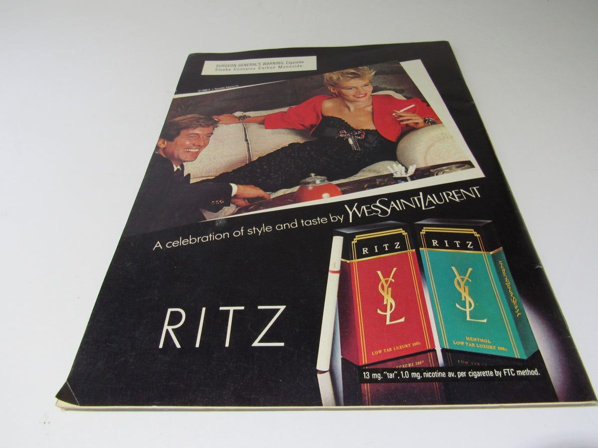 Vintage advertisement for Ritz cigarettes, featuring a stylish couple, showcasing a celebration of style and taste by Yves Saint Laurent, with a focus on luxury branding.