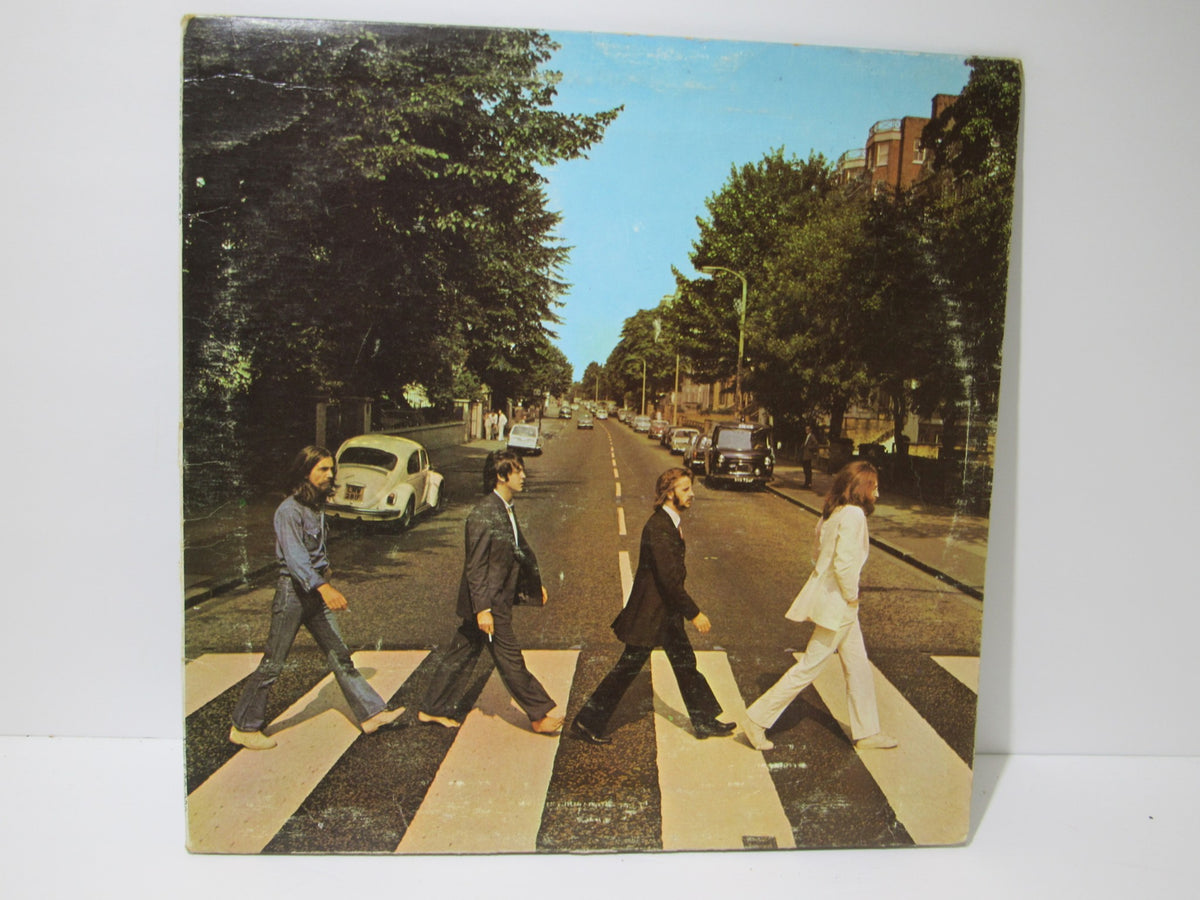 The Beatles: Abbey Road album cover featuring The Beatles crossing a street, a classic image from the iconic LP.