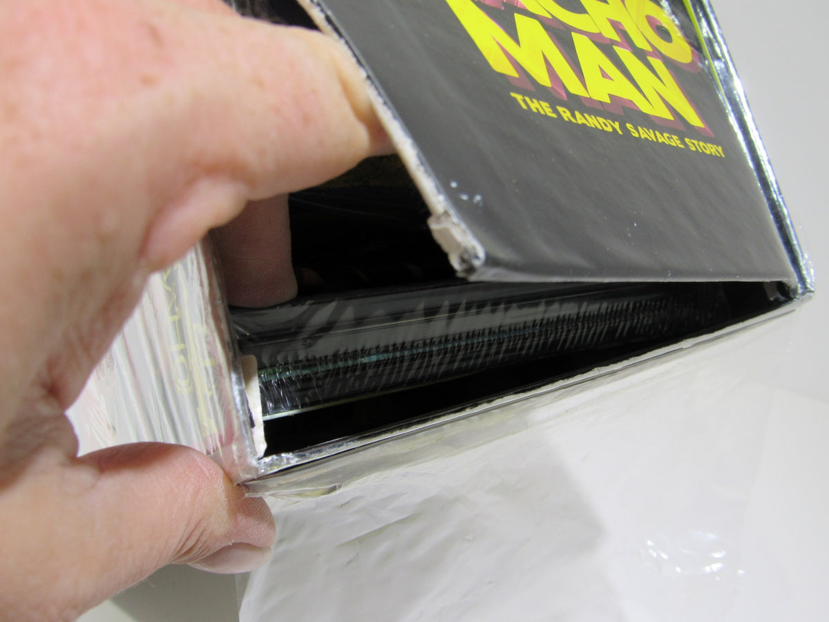 Close-up view of Macho Man: The Randy Savage Story Collector's Edition DVD being opened, highlighting its premium packaging.