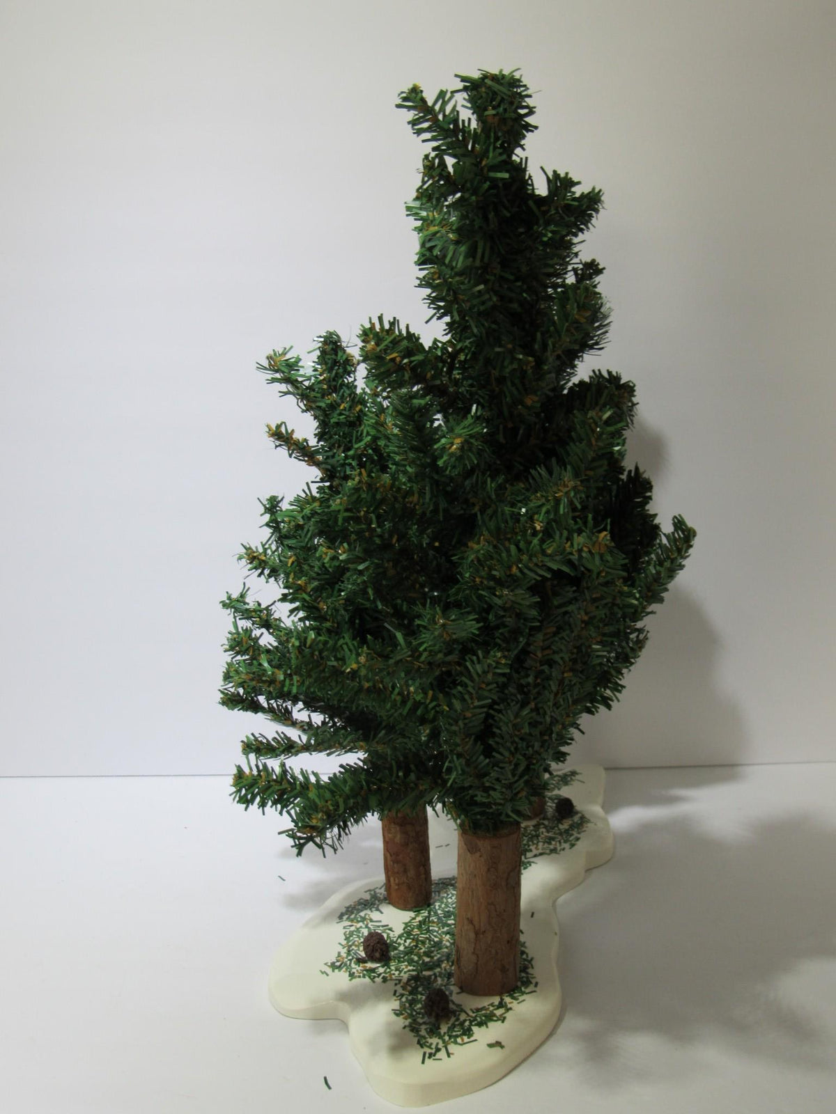 Side perspective of the Vintage Department 56 Village Spruce Tree Forest with Wooden Base #5248-5 displaying a cluster of green spruce trees on a snowy base.