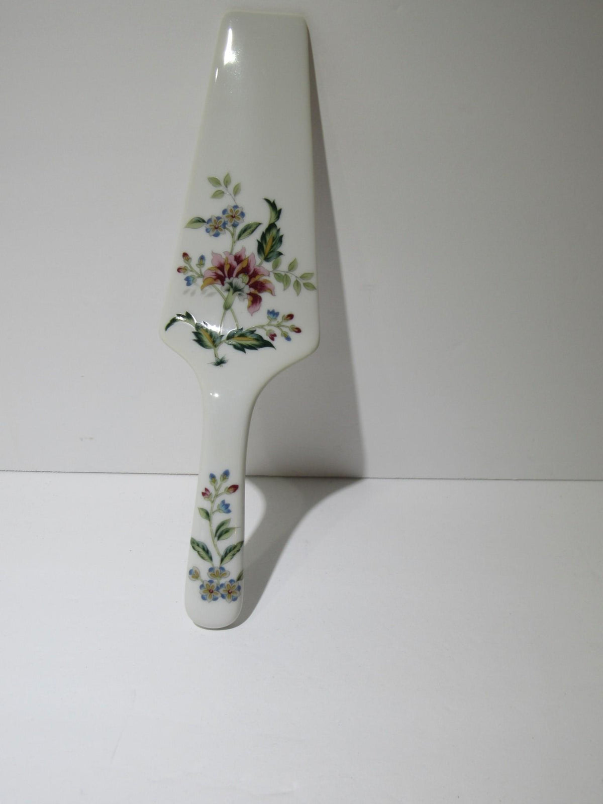 A porcelain cake server with a floral design and a sleek white handle from the VTG Andrea by Sadek Porcelain Cake Plate & Server Floral Pattern Japan Made NEW collection.