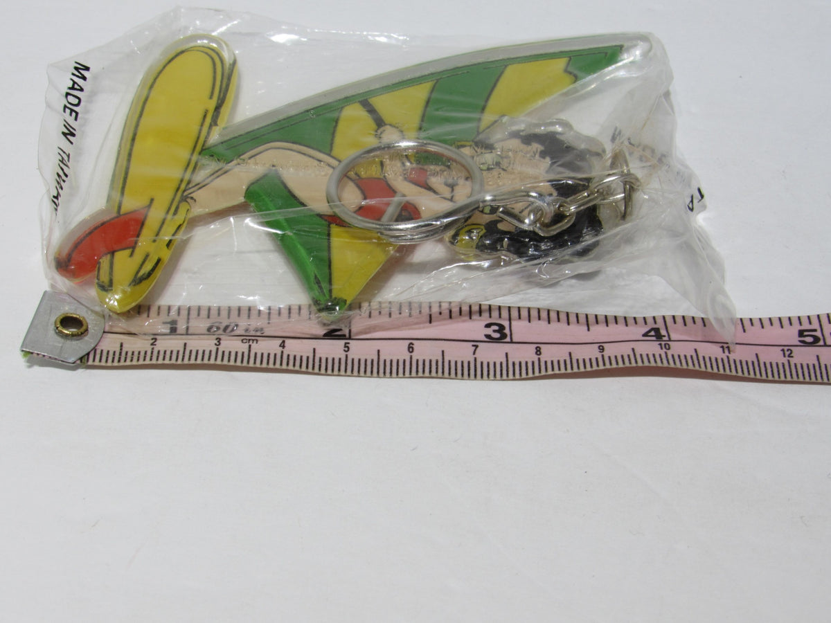 Close-up view of the 1985 Rare Vintage Surfing Betty Boop Key Chain, displaying Betty Boop on a surfboard with a measuring tape for size reference, brand new and collectible.