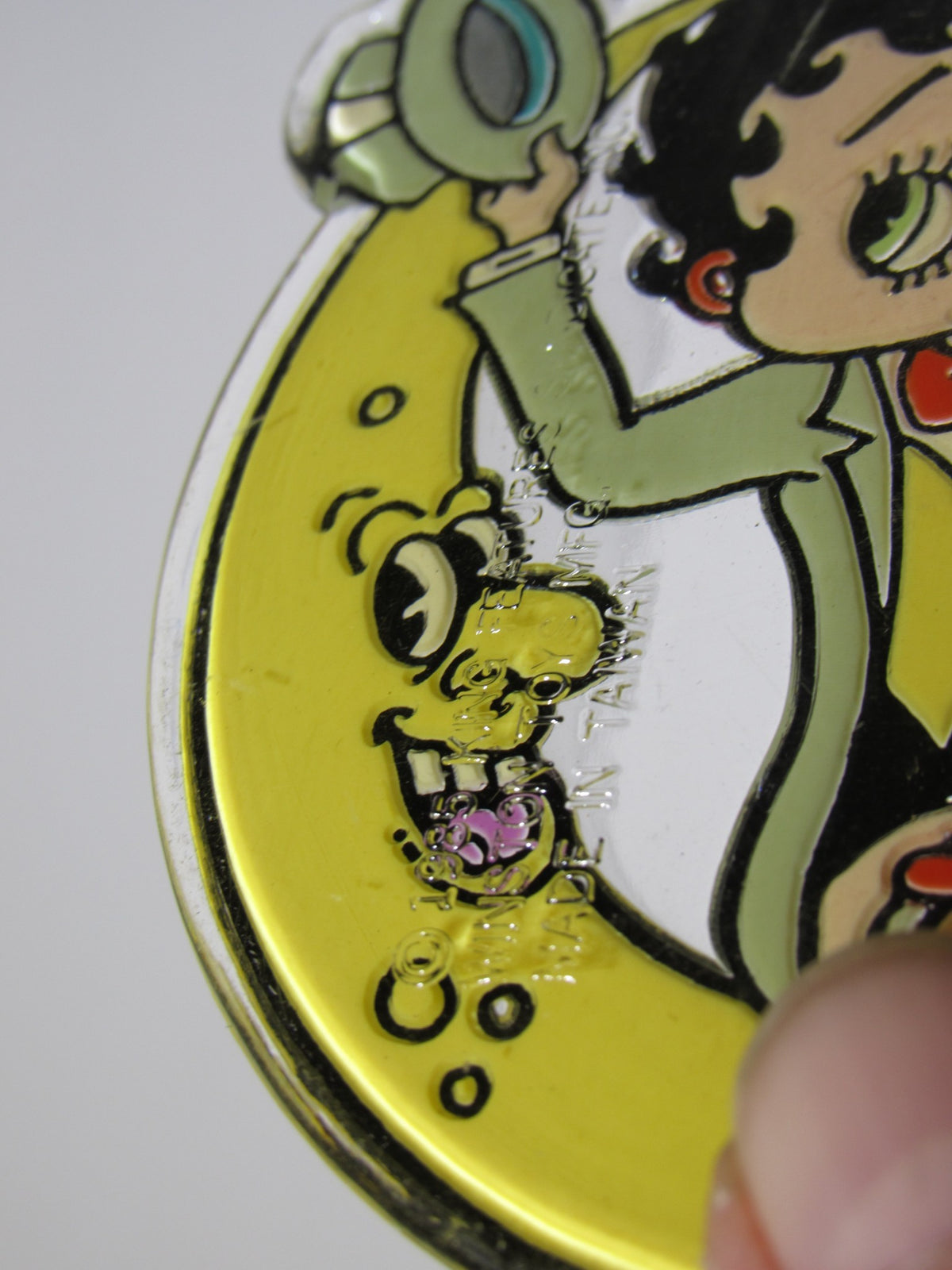 Close-up of a 1985 Rare Vintage Betty Boop On the Moon Key Chain featuring Betty Boop holding a magnifying glass, highlighting the vibrant colors and detailed design.