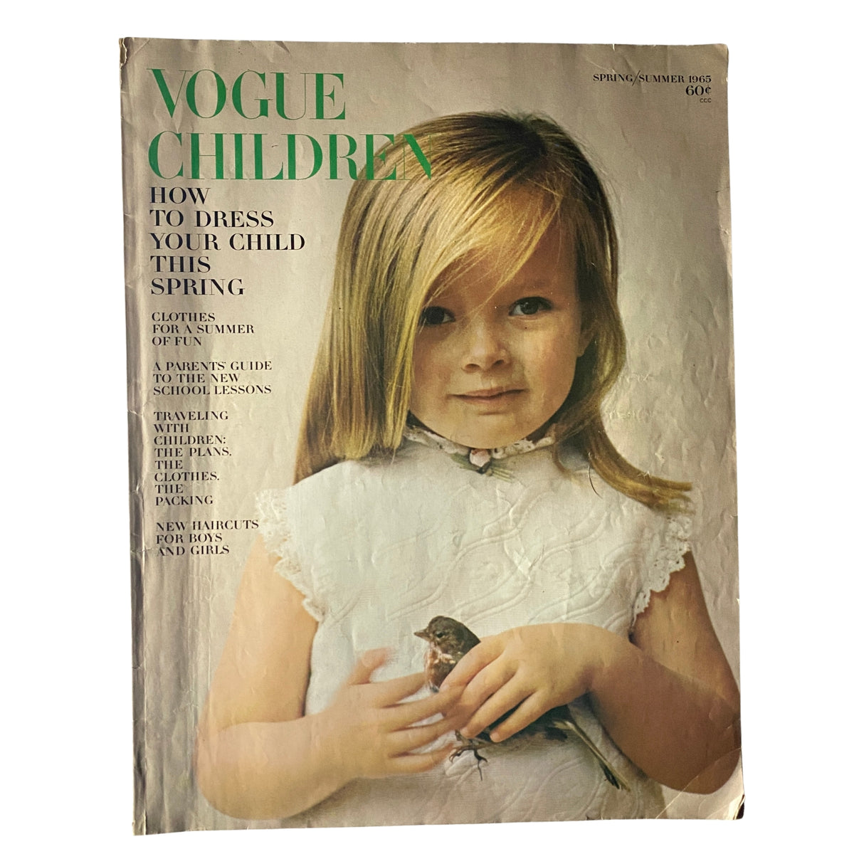 Cover of Vogue Children's Fashions - Spring Summer 1965 Catalog featuring a young girl with long hair, holding a bird, and showcasing the nostalgic fashion style of the era.