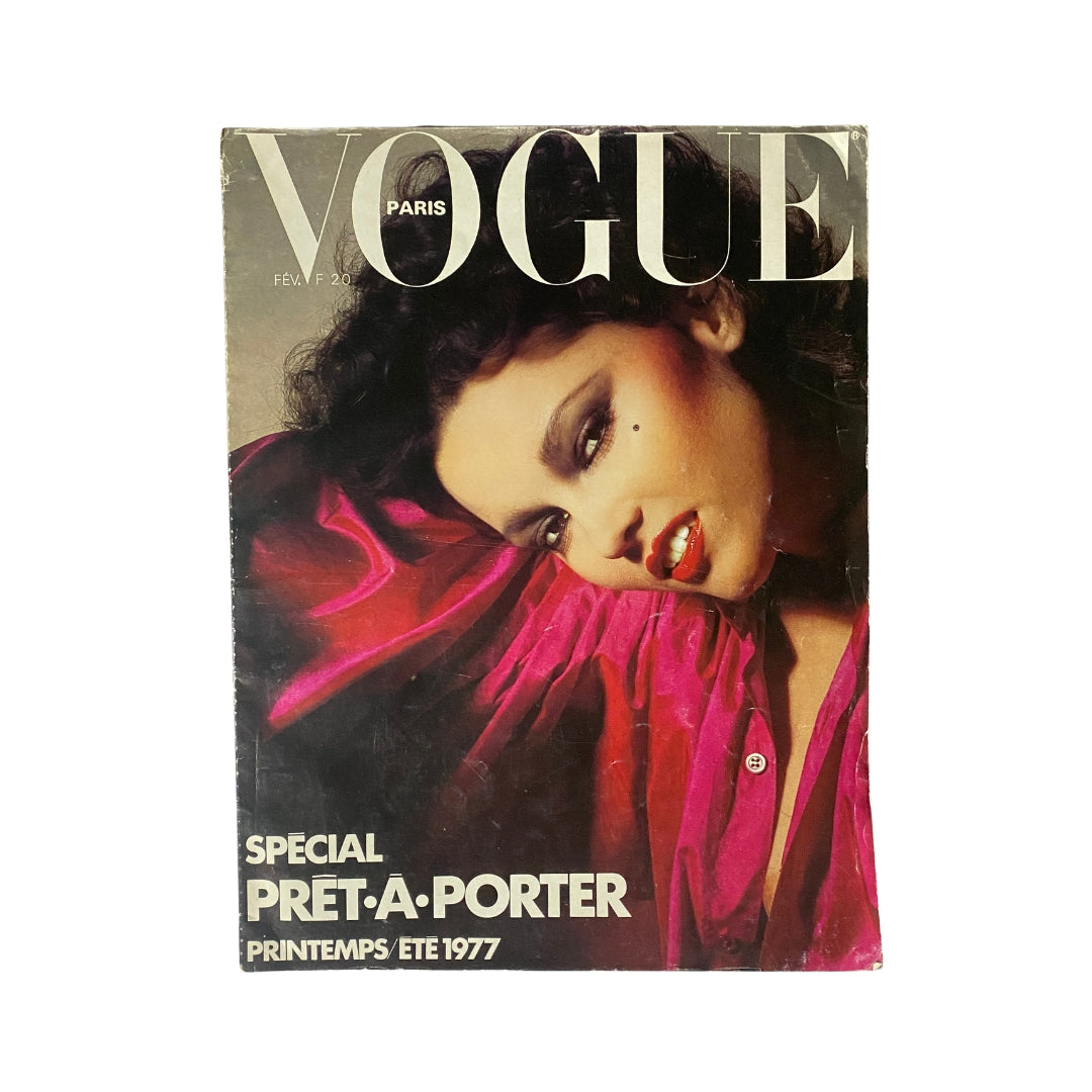 Vogue Paris Magazine February 1977 featuring a stunning cover photo by Guy Bourdin, showcasing model Marcie Hunt with bold makeup and vibrant clothing.