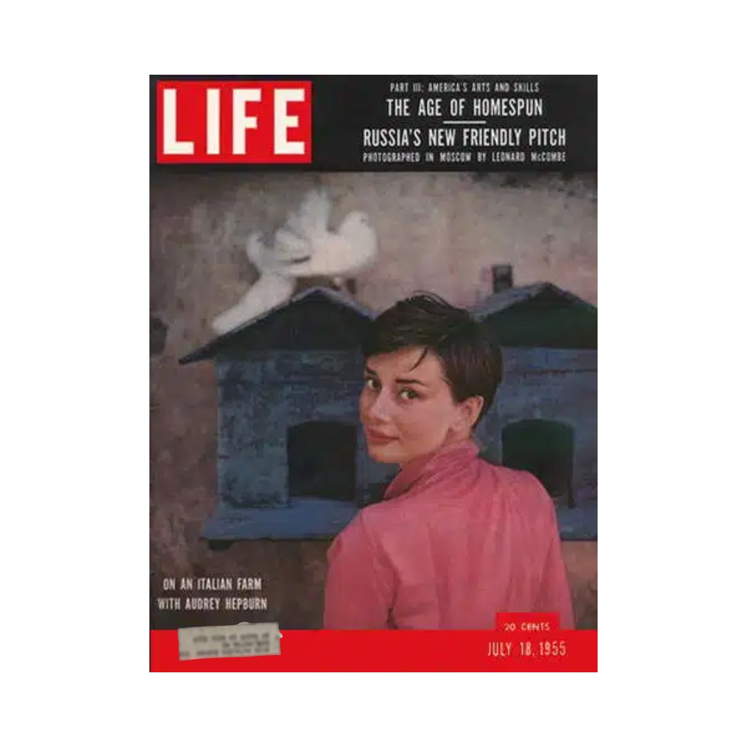 Vintage Life Magazine cover from July 18, 1955, featuring Audrey Hepburn on an Italian farm, showcasing part of the series America's Arts and Skills, with a backdrop of rustic buildings and doves.