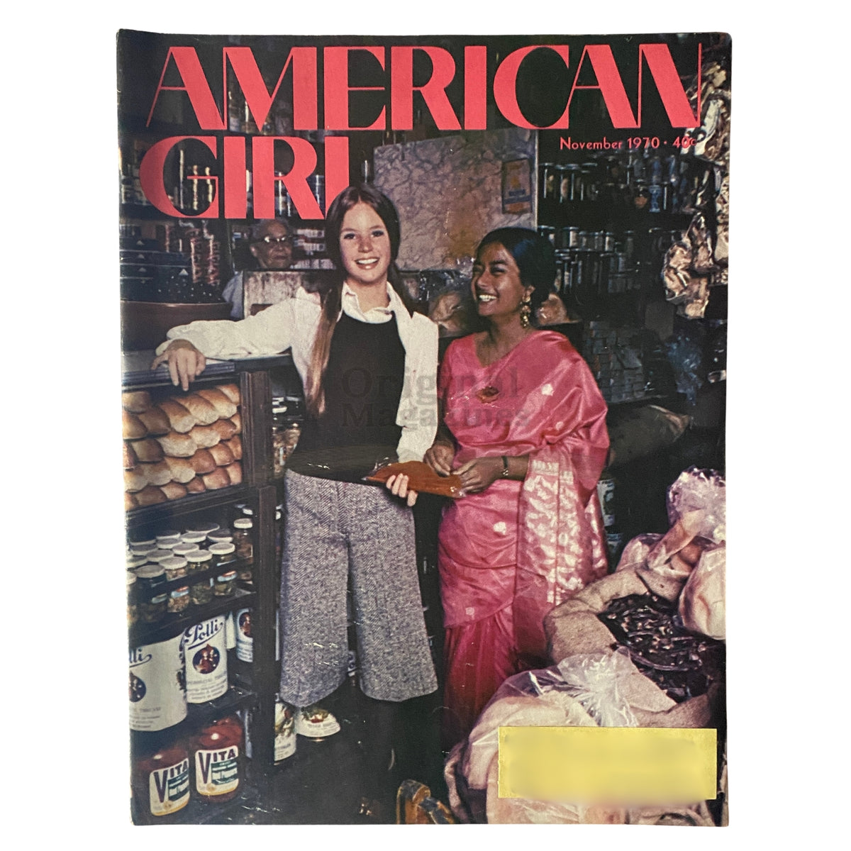 Cover of the American Girl Magazine from November 1970 titled 'The Movable Feast', featuring young women in a culturally rich market setting.